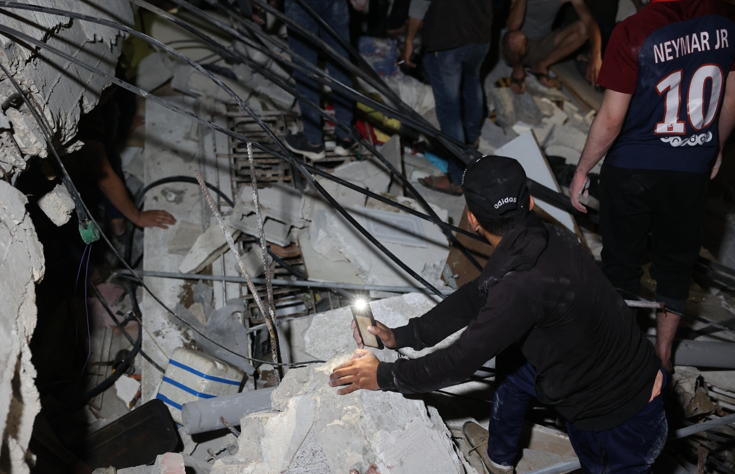 ފަލަސްތީން: ގާޒާ: މޭ 16، 2021: އިޒްރޭލުން ގާޒާއަށް ދެމުންދާ ބޮމުގެ ހަމަލާގައި މަރުވެފައިވާ ހަށިގަނޑުތައް ހޯދުމުގައި ފަލަސްތީނުގެ ފަޔާފައިޓާސް ހަރަކާތްތެރިވަނީ.-- ފޮޓޯ: އޭއެފްޕީ