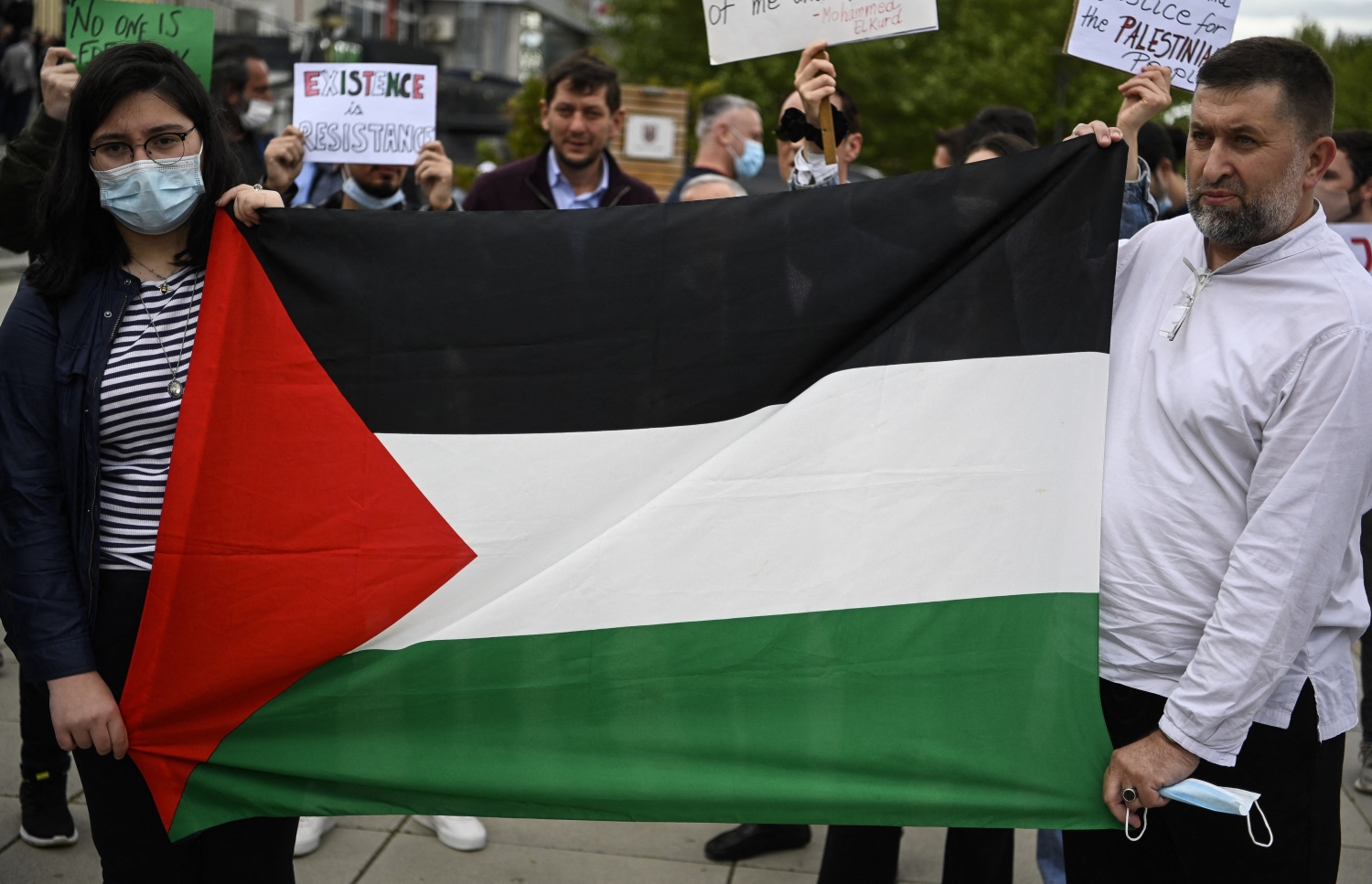 ކޮސޯވާ: މޭ 17، 2021: އިޒްރޭލުން ގާޒާއަށް ދެމުންދާ ބޮމުގެ ހަމަލާ އާއި ދެކޮޅަށް ކުރަމުންދާ މުޒާހަރާގައި ފަލަސްތީނާއެކު ވާކަން އެންގުމުގެ ގޮތުން ދުނިޔޭގެ އެކި ގައުމުތަކުގައި ބާއްވަމުންދާ މުޒާހަރާއެއްގައި ފަލަސްތީން މިނިވަންކުރުމަށް ގޮވާލާ ބަޔަކު އަޑުއުފުލަނީ.-- ފޮޓޯ: އޭއެފްޕީ