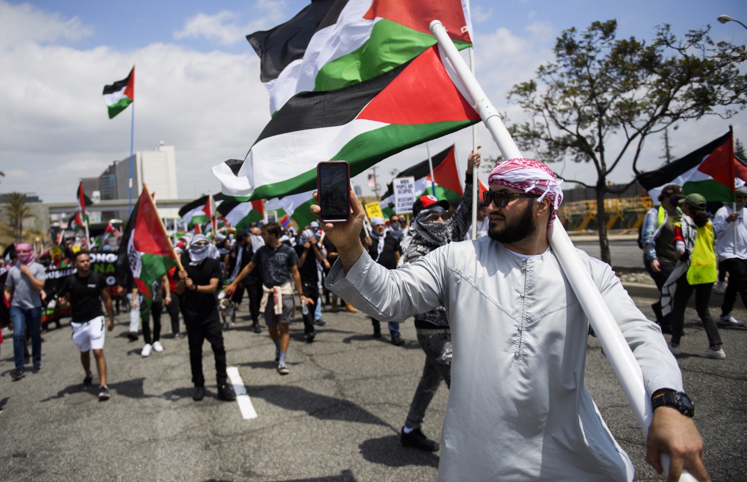 ލަސް ވޭގަސް: މޭ 17، 2021: އިޒްރޭލުން ގާޒާއަށް ދެމުންދާ ބޮމުގެ ހަމަލާ އާއި ދެކޮޅަށް ކުރަމުންދާ މުޒާހަރާގައި ފަލަސްތީނާއެކު ވާކަން އެންގުމުގެ ގޮތުން ދުނިޔޭގެ އެކި ގައުމުތަކުގައި ބާއްވަމުންދާ މުޒާހަރާއެއްގައި ބަޔަކު އަޑުއުފުލަނީ.-- ފޮޓޯ: އޭއެފްޕީ