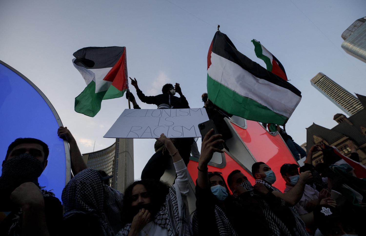 ކެނެޑާ: މޭ 17، 2021: އިޒްރޭލުން ގާޒާއަށް ދެމުންދާ ބޮމުގެ ހަމަލާ އާއި ދެކޮޅަށް ކުރަމުންދާ މުޒާހަރާގައި ފަލަސްތީނާއެކު ވާކަން އެންގުމުގެ ގޮތުން ދުނިޔޭގެ އެކި ގައުމުތަކުގައި ބާއްވަމުންދާ މުޒާހަރާއެއްގައި ބަޔަކު އަޑުއުފުލަނީ.-- ފޮޓޯ: އޭއެފްޕީ