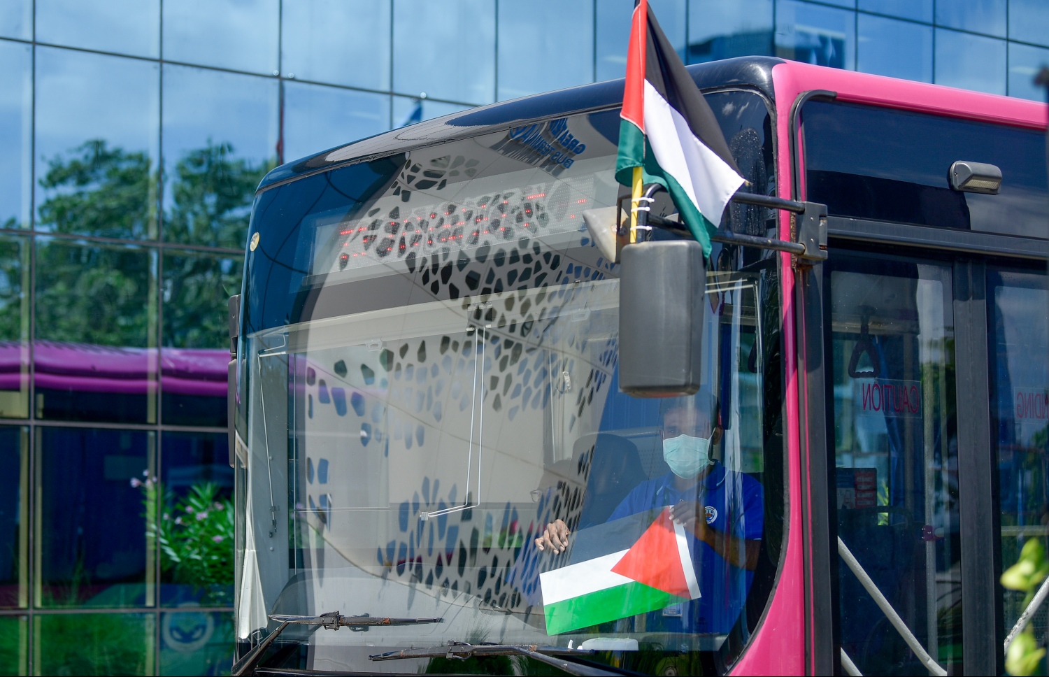 މާލެ-ހުޅުމާލެ އެމްޕީއެލް ބަހުގައި ފަލަސްތީނު ދިދަ ހަރުކޮށްފައި ހުރި އިރު ބަހުގެ ތެރޭގައި ހުރި މީހަކު ފަލަސްތީނުގެ ދިދަ ހިފައިގެން. -- ފޮޓޯ: ނިޝާން އަލީ / މިހާރު