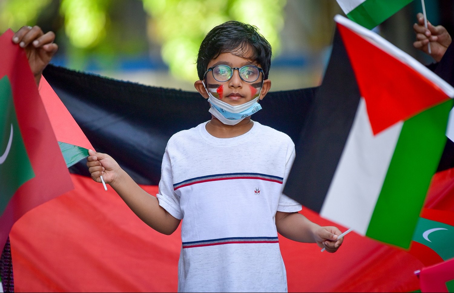 މާލެ- މޭއި 18، 2021: އިޒްރޭލުން ފަލަސްތީނަށް ދޭ ހަމަލާތަކާ ދެކޮޅުހަދައި ފަލަސްތީނާ އެކުގައި ތިބިކަން ހާމަކުރުމަށް ފަލަސްތީނު ދިދަ އާއި ދިވެހި ދިދަ ހިފައިގެން ކުޑަ ކުއްޖަކު ޝުއޫރު ފާޅުކުރަނީ --.ފޮޓޯ: ނިޝާން އަލީ/މިހާރު