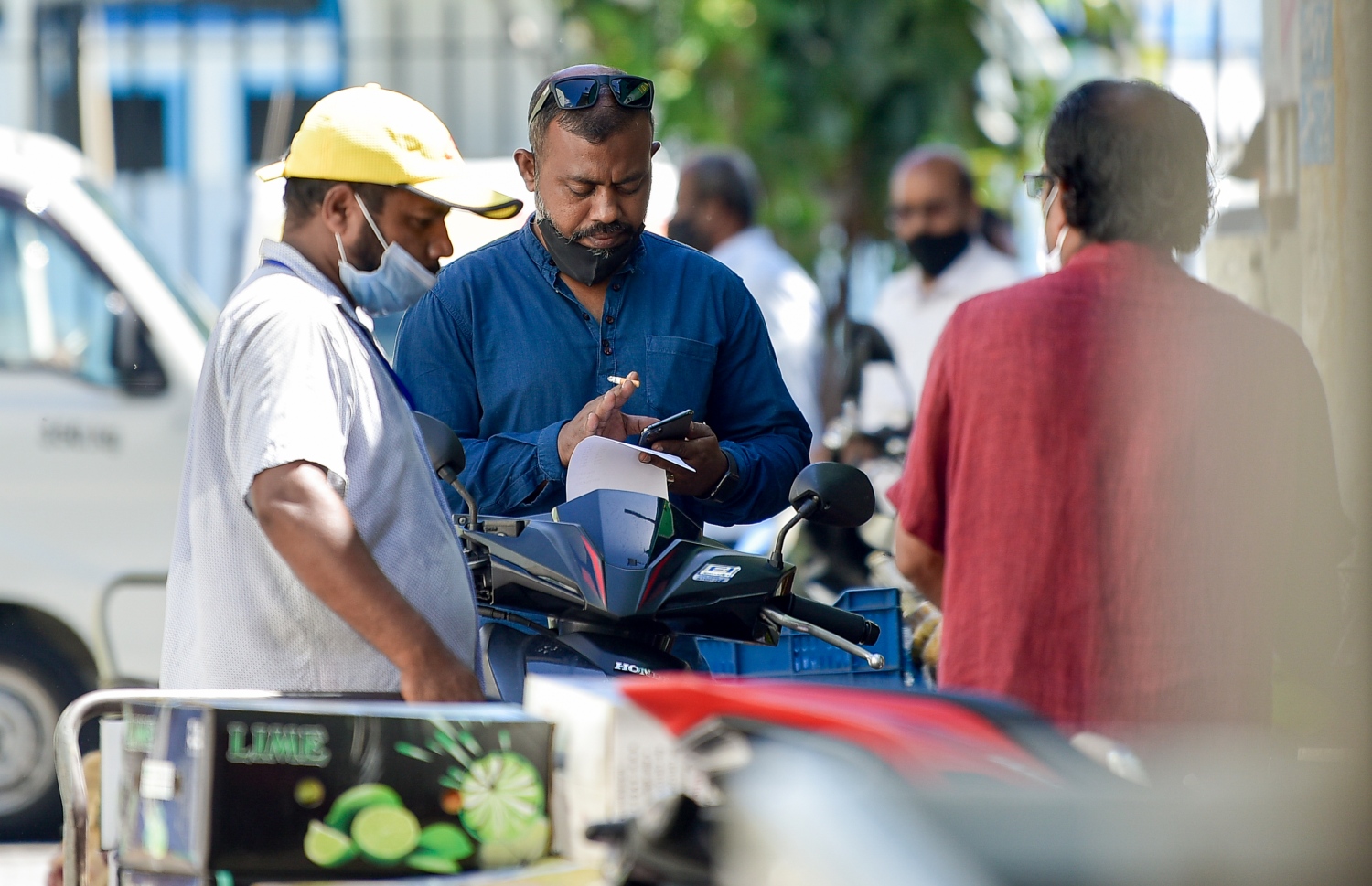 މާލޭގެ ބާޒާރުމަތީގެ ސަރަހައްދުގައި، ރަނގަޅަށް މާސްކު އަޅަން ސަމާލުކަން ނުދީ ތިބި ބަޔަކު މަޑުކޮށްލައިގެން: ކޮވިޑުން ރައްކާތެރިވާން އެންމެ މުހިންމު އެއް ފިޔަވަޅަކީ މާސްކު އެޅުން.---ފޮޓޯ: އަހުމަދު އަވްޝަން/މިހާރު