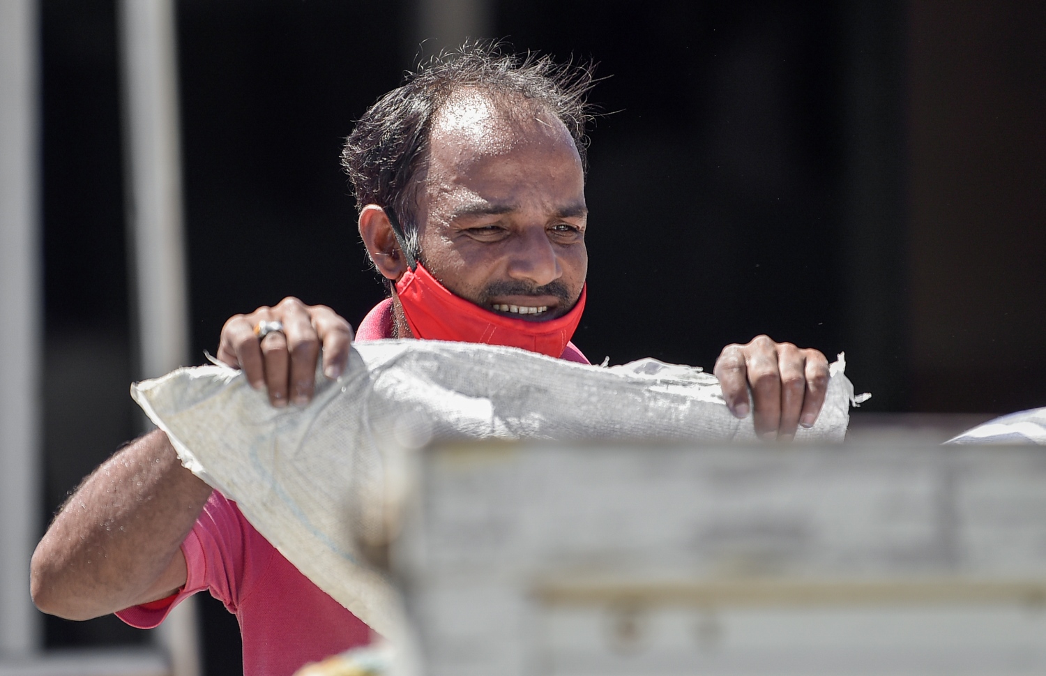 މާލޭގެ ބާޒާރުމަތީގެ ސަރަހައްދުގެ ފިހާރައަކަށް މީހަކު ފުށްބަސްތާތަކެއް އުފުލާއިރު، މާސްކް ދަތްދޮޅިއާ ހަމައަށް ތިރިކޮށްފައި: ކޮވިޑުން ރައްކާތެރިވުމަށް ތިމާ އާއި އެހެން މީހުންގެ ސަލާމަތަށް އޮތް އެންމެ މުހިންމު ކަމަކީ އަނގަމައްޗާއި އާއި ނޭފަތް ފޮރުވޭ ގޮތަށް މާސްކް އެޅުން.---ފޮޓޯ: އަހުމަދު އަވްޝަން/މިހާރު