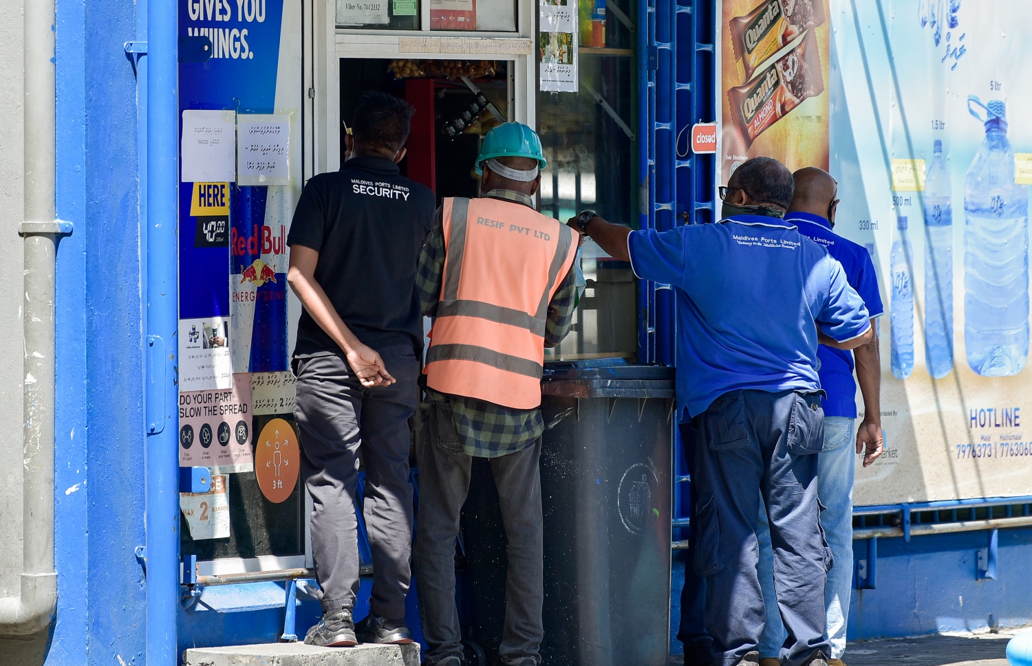 އެމްޕީއެލް ސަރަހައްދުގައި ހުރި ފިހާރައެއްގެ ދޮރުމަތީގައި ތިބި ބަޔަކު ގައިދުރުކަމެއް ނެތި ހިދުމަތް ހޯދަނީ: ކޮވިޑުން ރައްކާތެރިވާން އެންމެ މުހިންމު އެއް ކަމަކީ ގައިދުރުކަން ބެހެއްޓުމާއި މާސްކު އެޅުން.---ފޮޓޯ: އަހުމަދު އަވްޝަން/މިހާރު