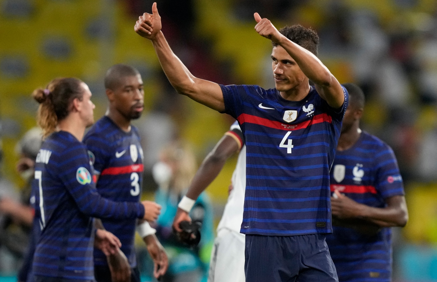 މިއުނިކް: ޖޫން 16، 2021: ޔޫރޯ 2020ގެ ގުރޫޕް އެފްގައި ފްރާންސް އާއި ޖަރުމަން ބައްދަލުކުރި މެޗު ނިންމާލުމަށްފަހު ފްރާންސްގެ ޑިފެންޑަރު ރަފޭލް ވަރާން ސްޕޯޓަރުންނަށް ހިނިތުންވެލަނީ: މި މެޗުގައި ޖަރުމަނު އަތުން 0-1 އިން ފްރާންސް ވަނީ ކުރިހޯދާފައި.-- ފޮޓޯ: އޭއެފްޕީ