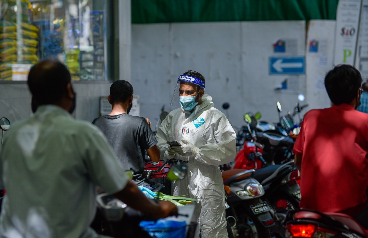 މާލެ- ޖޫން 21، 2021- މާލޭގެ މަގުމަތިން ކޮވިޑް ރެންޑަމް ސާމްޕަލް ނެގުމަށް، ޕީޕީއީ ލައިގެން ހަރަކާތްތެރިވި ފުލުހަކު، ސާމްޕަލް ނެގުމަށްޓަކައި މީހަކު ހުއްޓުވަނީ.---ފޮޓޯ: އަހުމަދު އަވްޝަން/މިހާރު