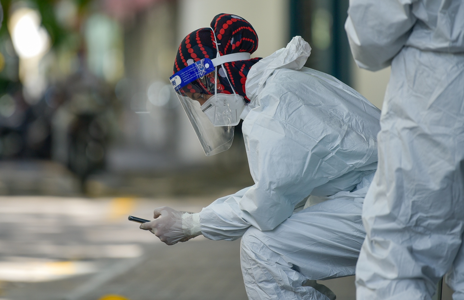 މާލެ- ޖޫން 21، 2021- މާލޭގެ މަގުމަތިން ކޮވިޑް ރެންޑަމް ސާމްޕަލް ނެގުމަށް ޕީޕީއީ ލައިގެން ހަރަކާތްތެރިވި ނަރުހަކު ވަރުބަލި ފިލުވައިލުމަށް އިށީނދެލައިގެން ފޯނާ ކުޅެނީ.---ފޮޓޯ: އަހުމަދު އަވްޝަން/މިހާރު