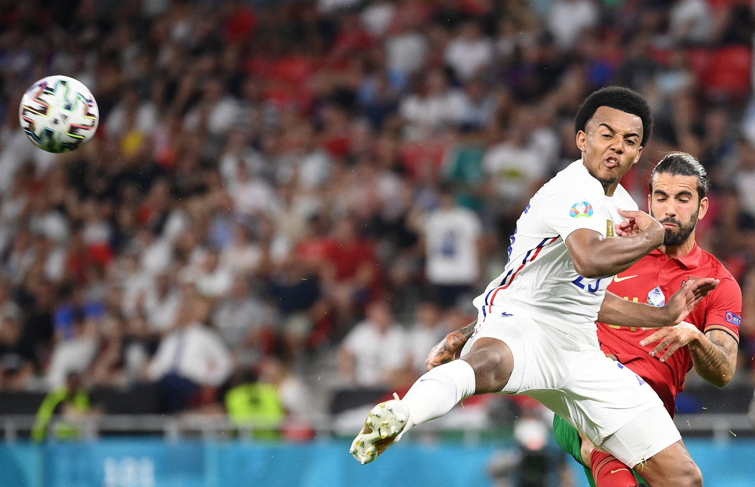 ބުޑަޕެސްޓް: ޖޫން 24، 2021: ޔޫރޯ 2020ގެ ގްރޫޕް އީގެ ފްރާންސް އާއި ޕޯޗުގަލް ބައްދަލުކުރި މެޗުގައި ފްރާންސްގެ ޑެފެންޑަރު ޖޫލް ކޯންޑޭ ފޮނުވާލި ބޯޅަ ހޯދުމަށް ޕޯޗުގަލްގެ މިޑްފީލްޑަރު ސާޖިއޯ އޮލީވިއާ މަސައްކަތް ކުރަނީ: ފްރާންސްގެ މައްޗަށް 2-2 ގެ ނަތީޖާ އަކުން އެއްވަރުކޮށް ޕޯޗްގަލް ވަނީ ދެވަނަ ބުރަށް ދަތުރު ކޮށްފައި.-- ފޮޓޯ: އޭއެފްޕީ