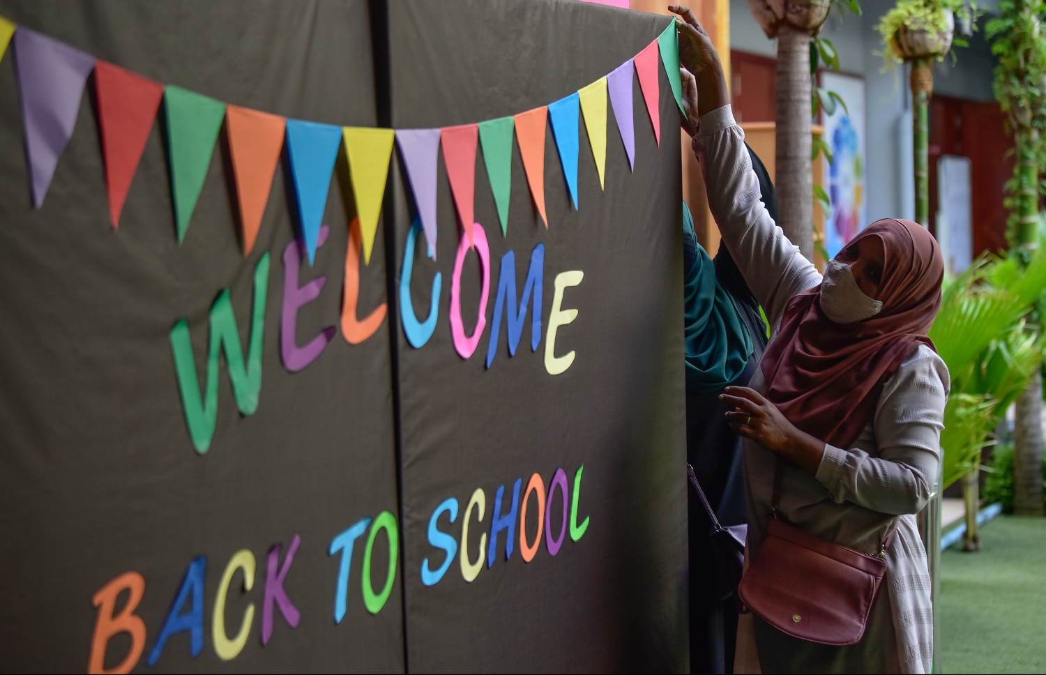 މާލެ- އޯގަސްޓް 9، 2021: ދަރިވަރުންނަށް މަރުހަބާ ކިއުމަށް އަހްމަދިއްޔާ ސްކޫލުގެ ޓީޗަރުން ބެނާއެއް ތައްޔާރުކުރަނީ، ކޮވިޑްގެ ސަބަބުން ސްކޫލްތައް ބަންދުކޮށް، އޮންލައިންކޮށް ކިޔަވައިދޭތާ އަހަރެއްހާ ދުވަސް ފަހުން މާދަމާ ކިޔެވުން ފަށަނީ ސްކޫލަށް ދަރިވަރުން ހާޒިރުވާ ގޮތަށް--. ފޮޓޯ: ނިޝާން އަލީ/މިހާރު