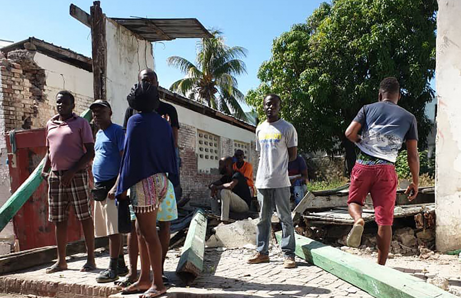 އޮގަސްޓް 14، 2021 ގައި ހައިޓީގެ ހުޅަނގު ދެކުނު ސަރަހައްދަށް އައި ބާރުގަދަ ބިންހެލުމުގައި ވެއްޓިފައިވާ އިމާރާތެއްގެ ކައިރީގައި ބަޔަކު މަޑުކޮށްލައިގެން. --އޭއެފްޕީ