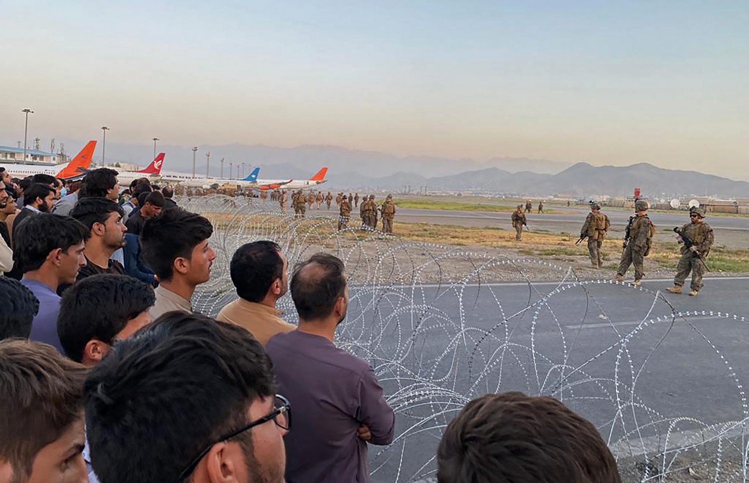 ތާލިބާންގެ ހަނގުރާމަވެރިން އަފްގާނިސްތާން ހިފުމާ ގުޅިގެން، އެ ގައުމުން ހުޅަނގުގެ ޑިޕްލޮމޭޓުން ބޭރުކުރުމަށް ކުރަމުންދާ މަސައްކަތުގެ ތެރެއިން، އެ ގައުމު ދޫކޮށް ދާން ބޭނުންވާ އަފްގާނިސްތާނުގެ އާންމުންގެ ބަޔަކު، އޮގަސްޓް 16، 2021 ގައި ކާބުލްގެ ވައިގެ ބަނދަރުގައި މަޑުކޮށްލައިގެން. --އޭއެފްޕީ