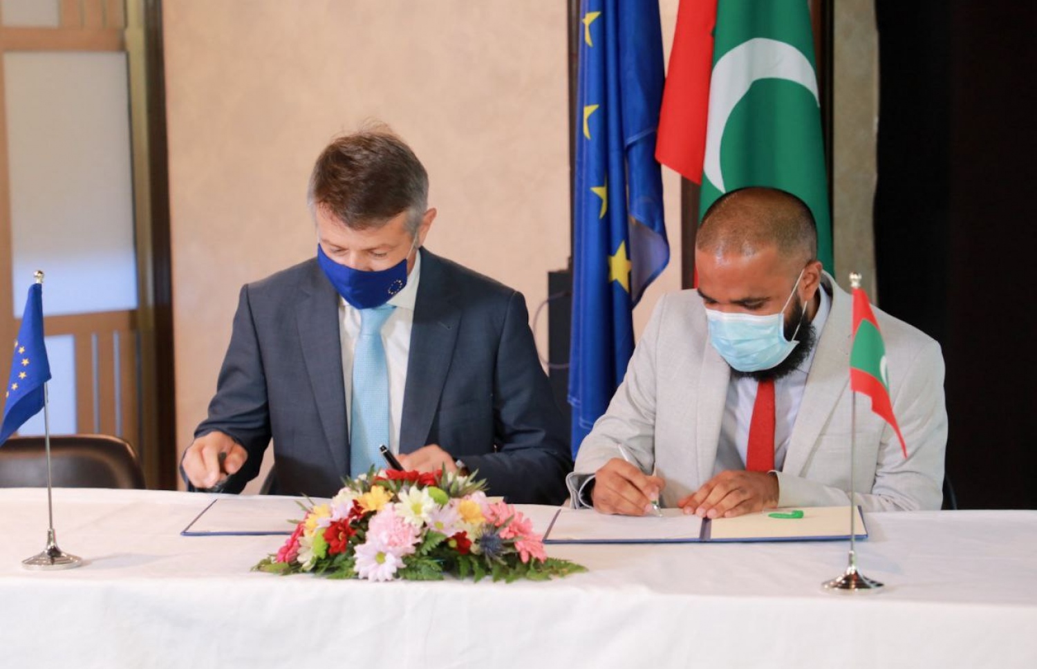 އީޔޫ އިން ރާއްޖެއަށް ކަނޑައަޅުއްވާފައި ހުންނަވާ ސަފީރު ޑެނިސް (ވ) އާއި އެމްއެފްއެމްސީގެ މެނޭޖިން ޑިރެކްޓަރު ހަސަން މަނިކު (ކ) އެއްބަސްވުމުގައި ސޮއި ކުރައްވަނީ-- ފޮޓޯ: އިކޮނޮމިކް މިނިސްޓްރީ