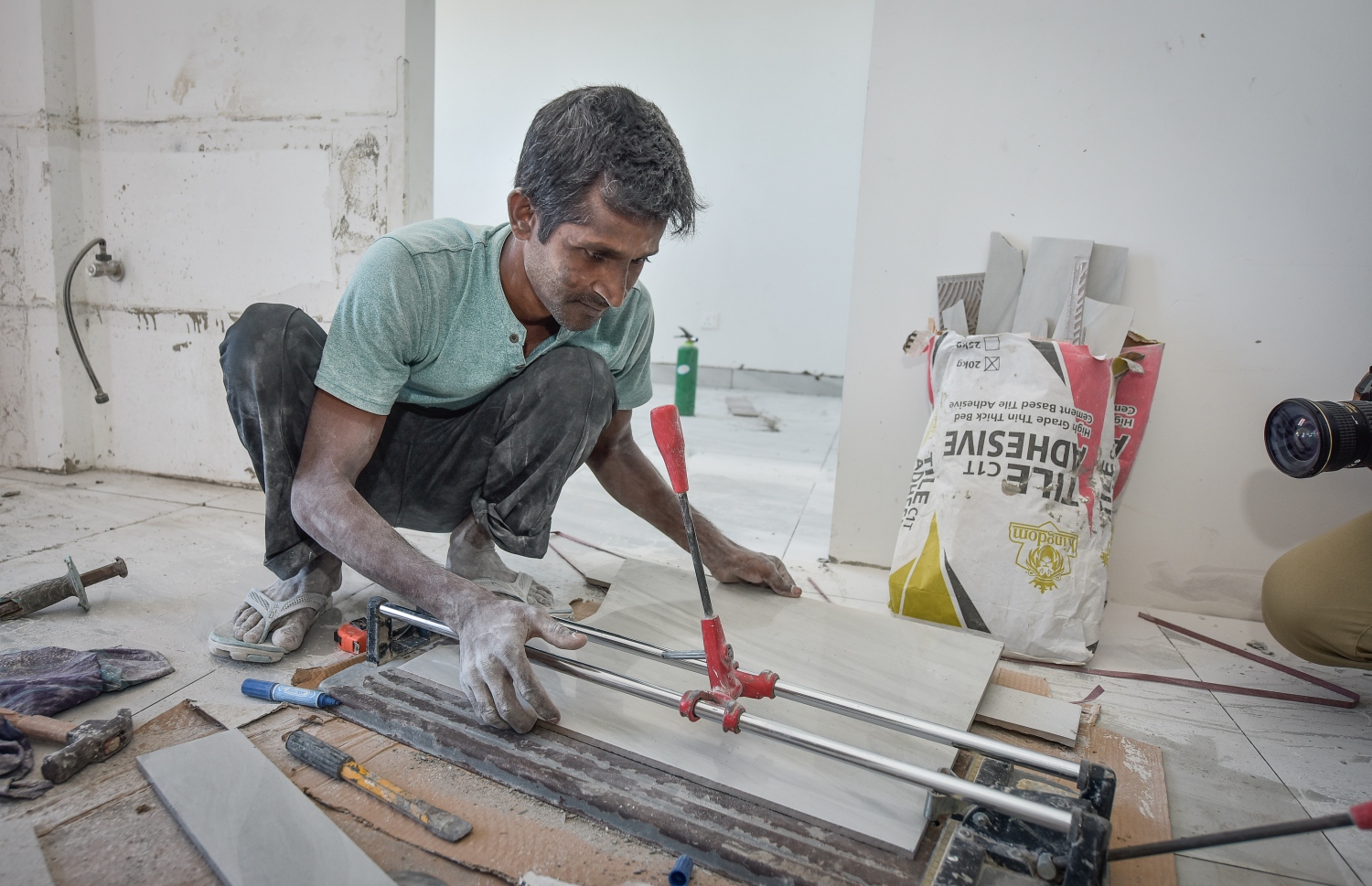 ބިދޭސީއަކު ފްލެޓެއްގައި ޓައިލްސް ޖެހުމުގެ މަސައްކަތް ކުރަނީ-- ފޮޓޯ: ނިޝާން އަލީ/މިހާރު