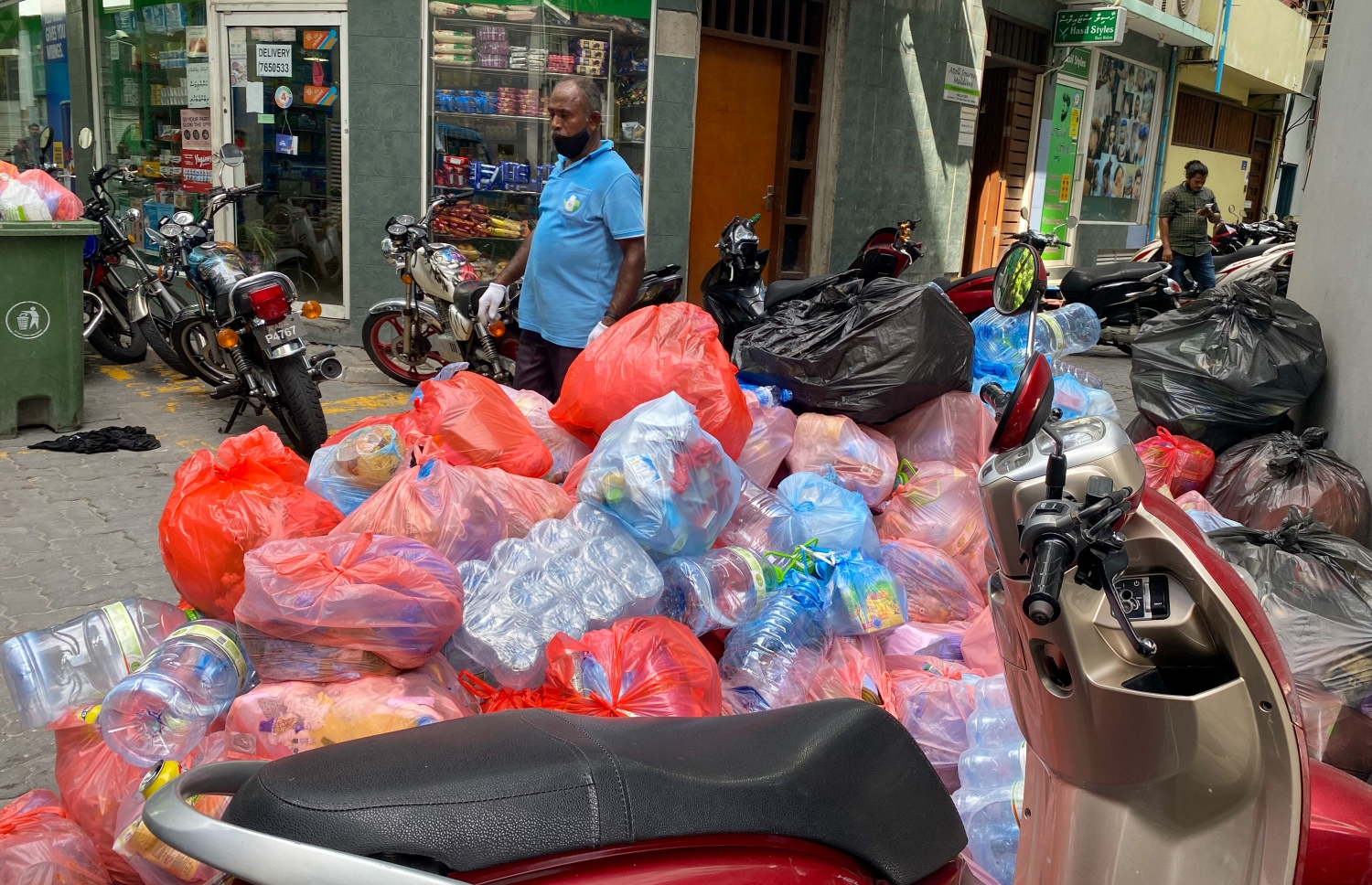 މާލެ: ސެޕްޓެމްބަރު 16، 2021: މާލެ ސިޓީ ކައުންސިލްގެ މުއައްޒަފަކު މާލޭގެ މަގުތަކަށް ނެރިފައި ހުރި ކުނިތައް މިއަދު މެންދުރުގެ ވަގުތުގައި އުކާލަނީ .-- ފޮޓޯ: އަހުމަދު އަވްޝަން / މިހާރު