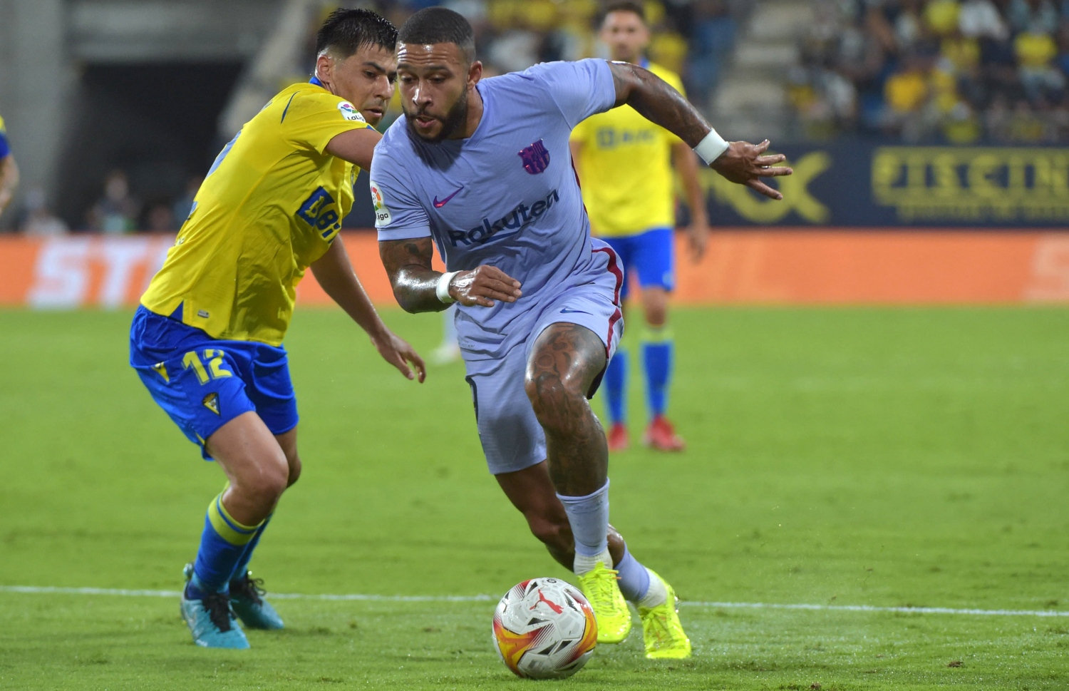 ބާސެލޯނާގެ ފޯވަޑް މެމްފިސް ޑިޕާއީ ކާޑިޒްގެ މިޑްފީލްޑަރު ކައިރިން ބޯޅަ ހިފައިގެން ދަނީ. -- ފޮޓޯ: އޭއެފްޕީ