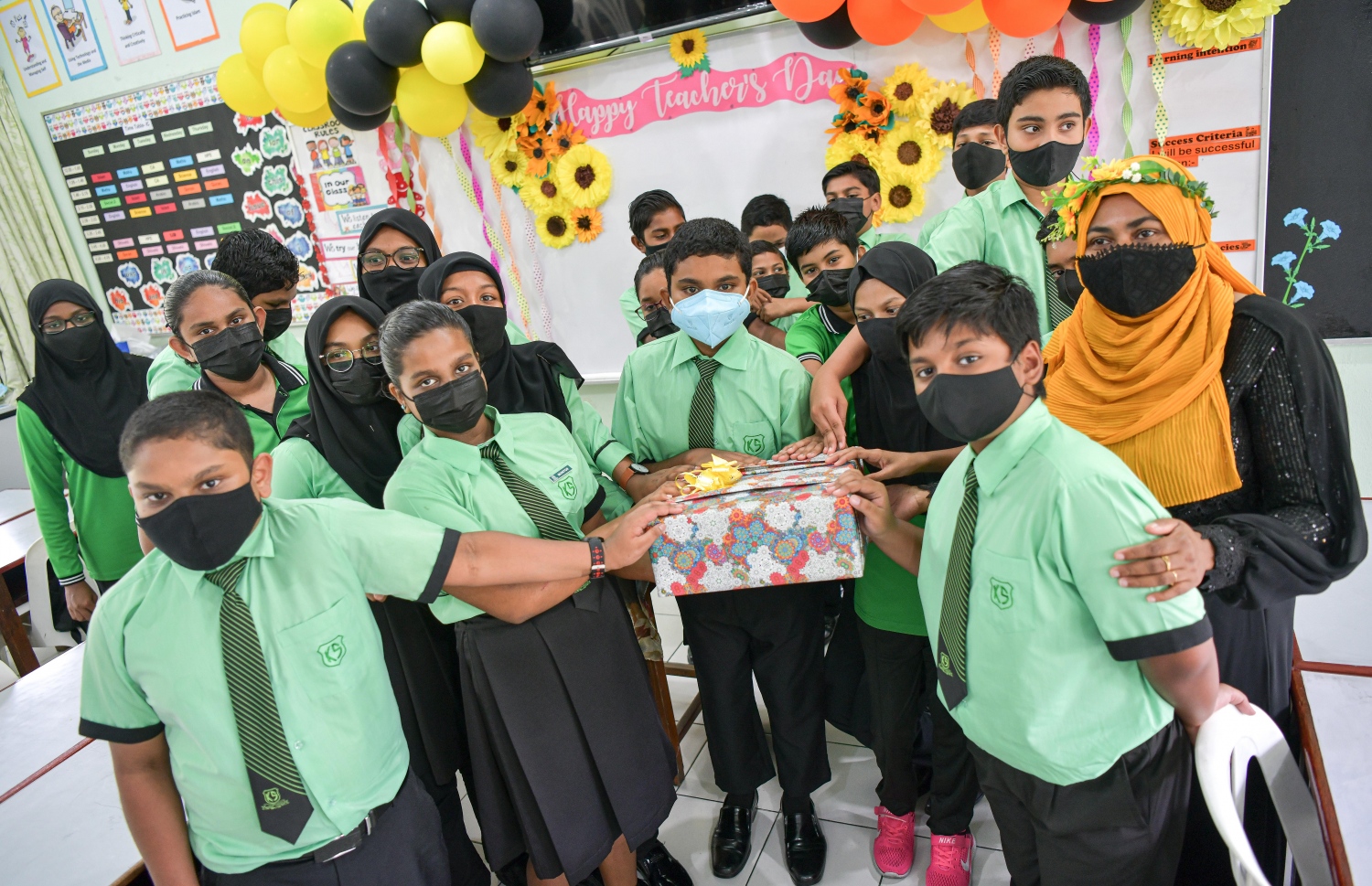 ޓީޗަރުންގެ ދުވަހާ ގުޅުވައިގެން ކަލާފާނު ސްކޫލުގެ ދަރިވަރުންތަކެއް، ޓީޗަރަކަށް ހަދިޔާއެއް ދެނީ.-- ފޮޓޯ: ފަޔާޒު މޫސާ/ މިހާރު