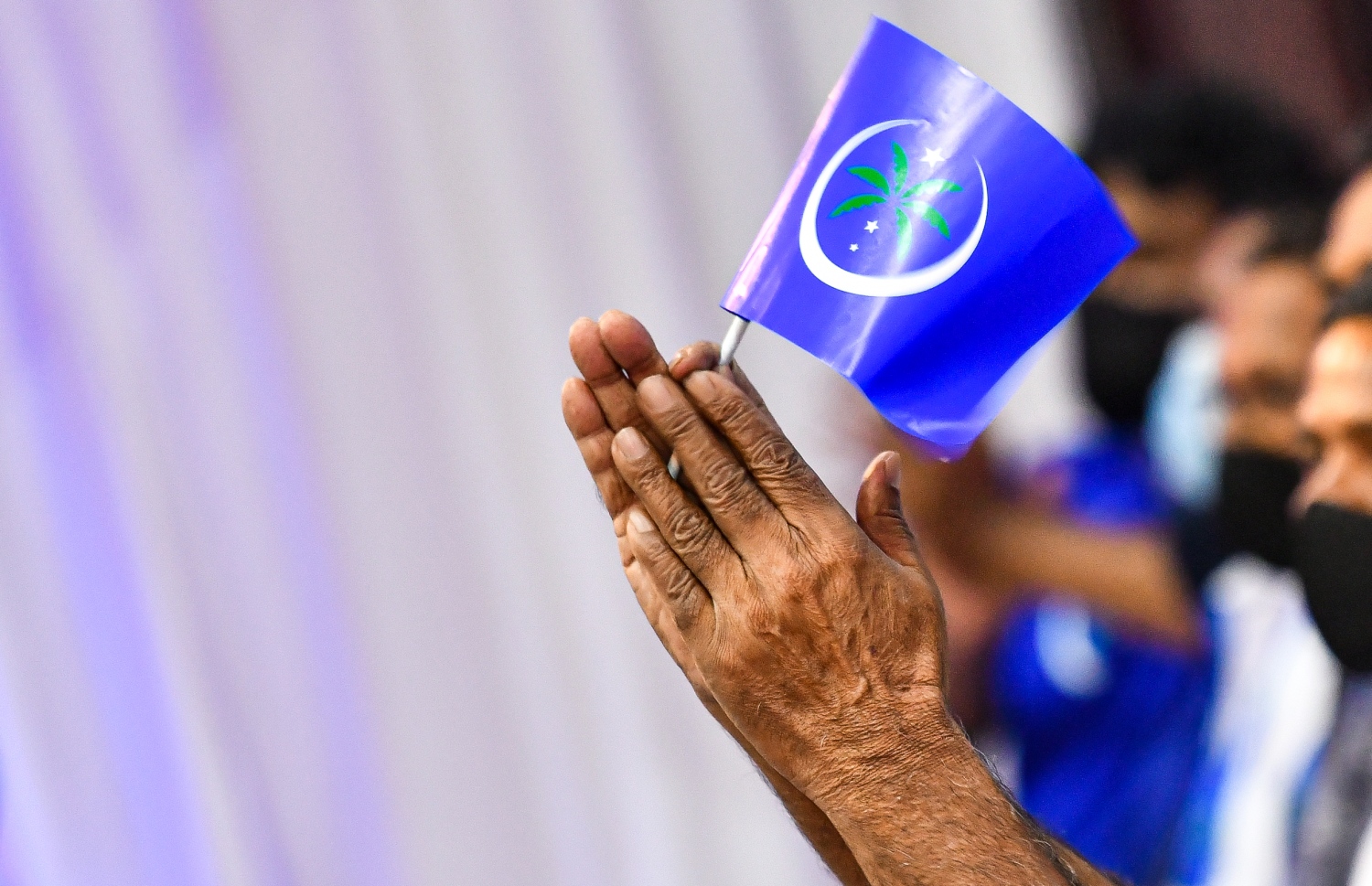 މާލެ: އޮކްޓޯބަރު 8، 2021- މޯލްޑިވްސް ނޭޝަނަލް ޕާޓީ (އެމްއެންޕީ) އުފައްދަން މިރޭ ޣިޔާސުއްދީން ސްކޫލުގައި ބޭއްވި ޖަލްސާގައި، އެ ޕާޓީގެ ދިދަ ހިފައިގެން ހުރި މީހަކު އަތްޖަހަނީ.---ފޮޓޯ: ފަޔާޒް މޫސާ/މިހާރު