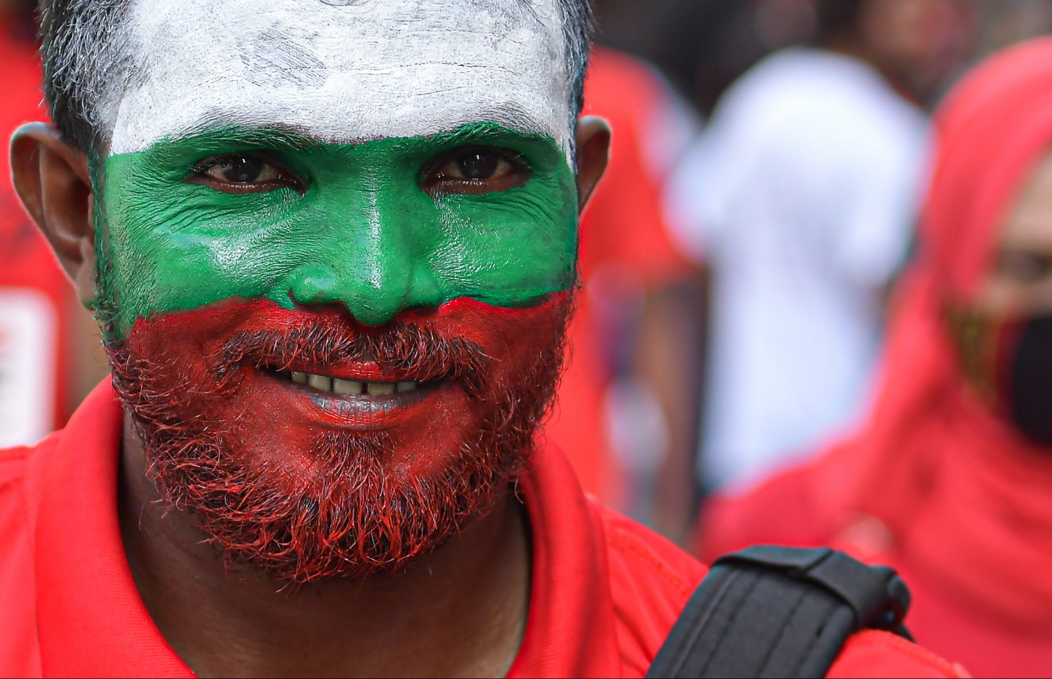 މާލެ: އޮކްޓޯބަރު 10، 2021- ސާފްޗެމްޕިއަންޝިޕް ފުޓުބޯޅަ މުބާރާތުގައި ރާއްޖެ-ލަންކާ ކުޅުނު ފޯރިގަދަ މެޗުގައި ދިވެހި ޓީމުގެ ސަޕޯޓަރަކު އެ ޓީމާއެކު ހުރިކަން ދައްކައި ދިނުމަށް ދިވެހި ދިދައިގެ ކުލަތަކުން މޫނު ޖަރީކޮށްފައި.---ފޮޓޯ: ނިޝާން އަލީ/ މިހާރު