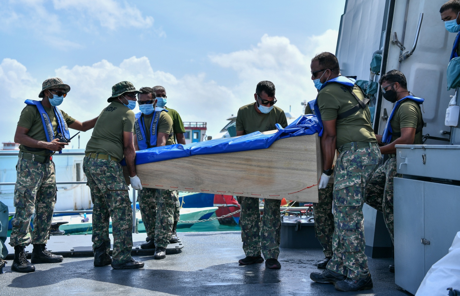 ދަނގެތި: އޮކްޓޯބަރު 15، 2021- މި ރަށުގައި އިހާނެތިކޮށް މަރާލައި އެއްލާލާފައި އޮއްވައި ފެނުނު ވިޔަފާރިވެރިޔާ މަހުމޫދު އަބޫބަކުރުގެ ހަށިގަނޑުގެ ޓެސްޓްތަކެއް ހެދުމަށް ފަހު ކޯސްޓްގާޑްގައި މިއަދު އަބުރާ ދަނގެއްޗަށް ގެންނަނީ.-- ފޮޓޯ: ނިޝާން އަލީ/ މިހާރު