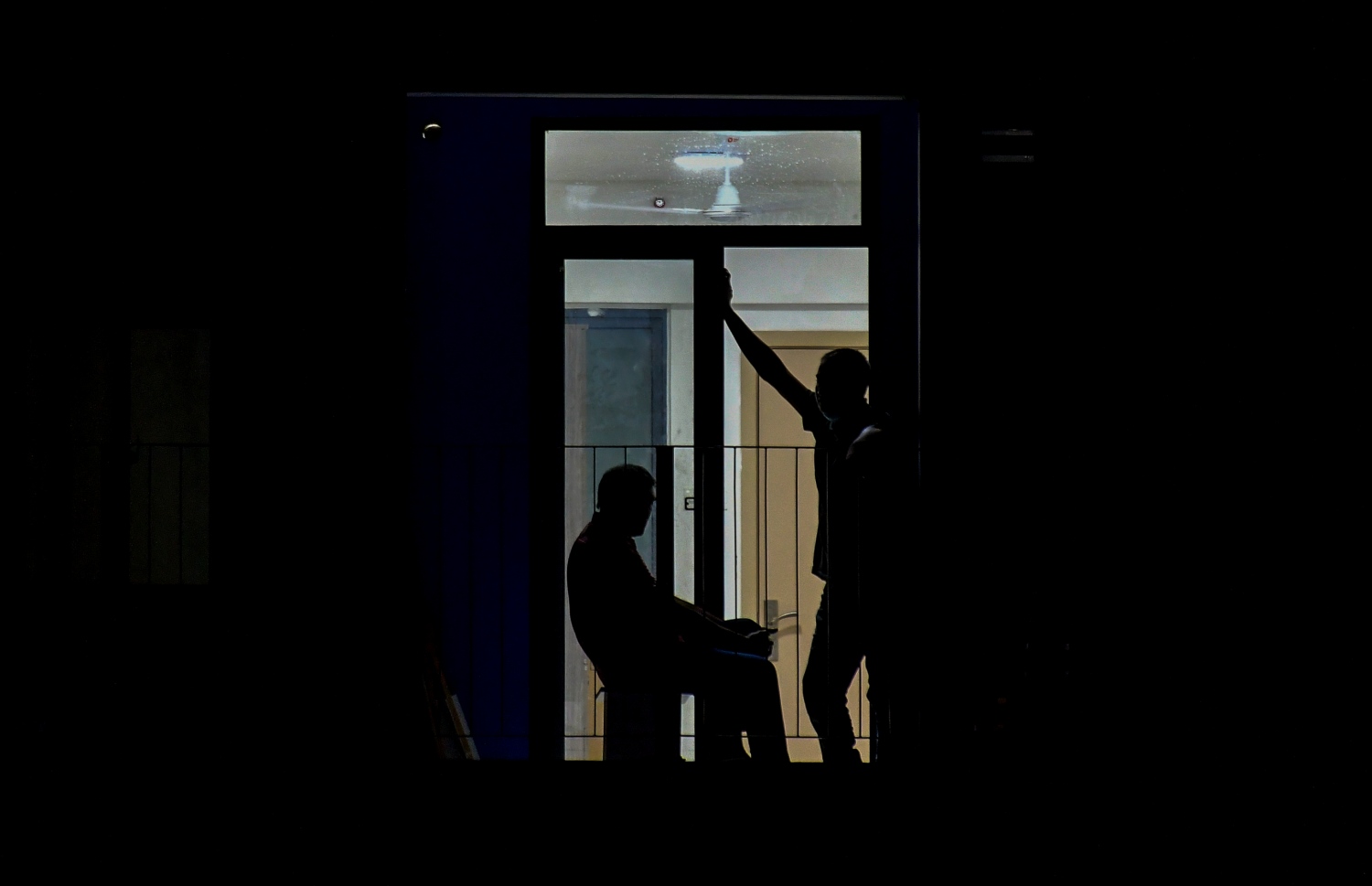 ހުޅުމާލެ ދެވަނަ ފިޔަވަހި: އޮކްޓޫބަރު 21، 2021: އަނދިރީގައި އޮތް ހިޔާ ފްލެޓް ހިމެނޭ ސަރަހައްދަށް އަލިކަމާ ދިރުން ލިބެން ފެށުން: 300 އާއިލާ ވަނީ މިހާރު ހިޔާ ފުލެޓްގައި ދިރިއުޅެން ފަށާފައިވާއިރު، ދެ މީހަކު ބެލްކަނީގައި ވާހަކަ ދައްކާލަން މަޑުކޮއްލައިގެން.-- ފޮޓޯ: ފަޔާޒު މޫސާ / މިހާރު