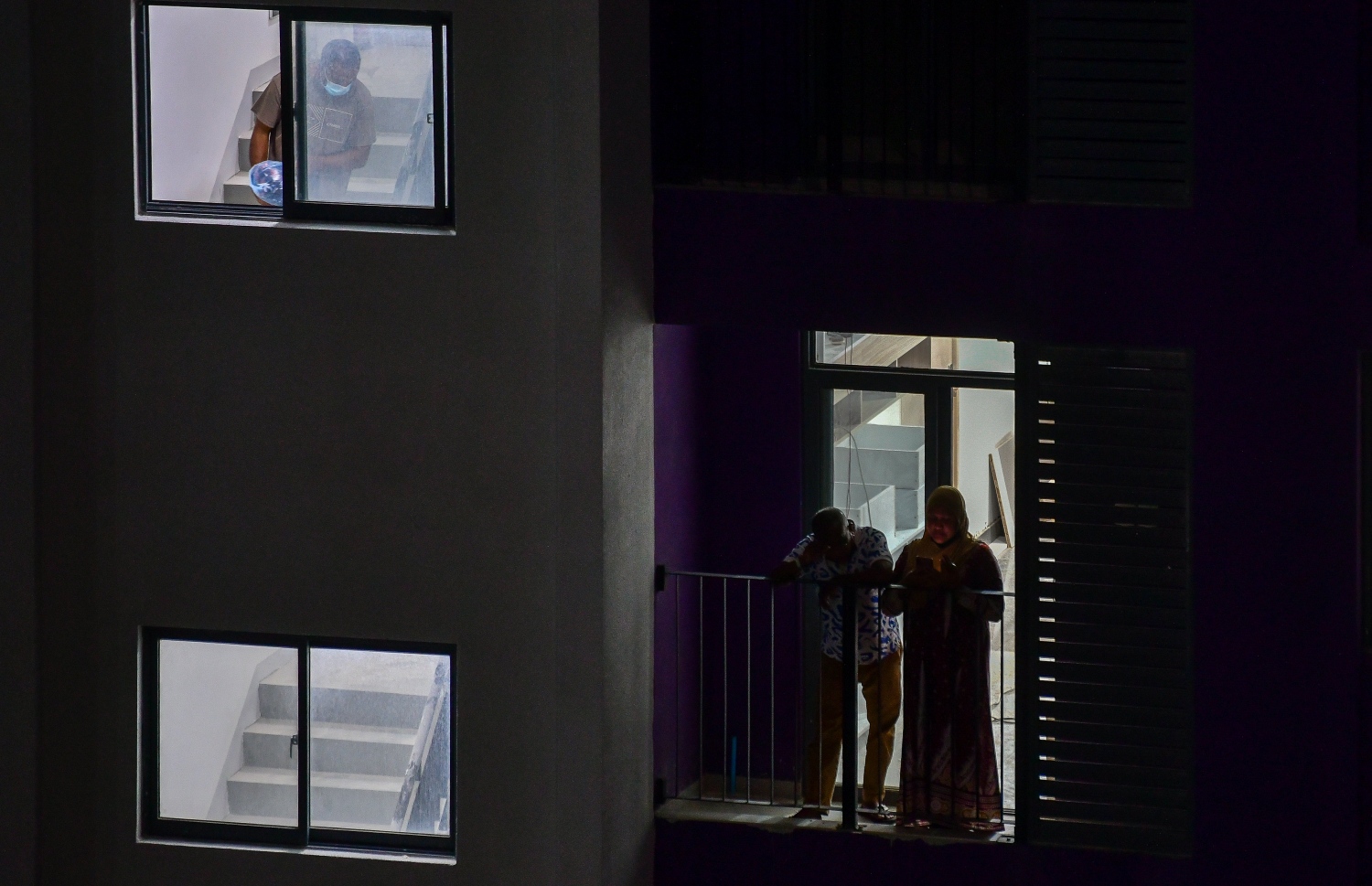 ހުޅުމާލެ ދެވަނަ ފިޔަވަހި: އޮކްޓޫބަރު 21، 2021: އަނދިރީގައި އޮތް ހިޔާ ފްލެޓް ހިމެނޭ ސަރަހައްދަށް އަލިކަމާ ދިރުން ލިބެން ފެށުން: 300 އާއިލާ ވަނީ މިހާރު ހިޔާ ފުލެޓްގައި ދިރިއުޅެން ފަށާފައިވާއިރު، ދެ މީހަކު ބެލްކަނީގައި ވާހަކަ ދައްކާލަން މަޑުކޮއްލައިގެން.-- ފޮޓޯ: ފަޔާޒު މޫސާ / މިހާރު