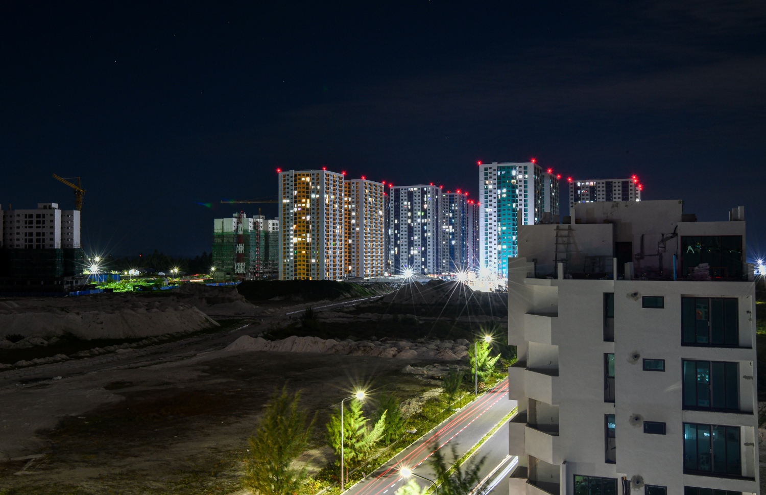 ހުޅުމާލެ ދެވަނަ ފިޔަވަހި: އޮކްޓޫބަރު 21، 2021: އަނދިރީގައި އޮތް ހިޔާ ފްލެޓް ހިމެނޭ ސަރަހައްދަށް އަލިކަމާ ދިރުން ލިބެން ފެށުން: ހުޅުމާލޭ ފޭސް 2ގައި ހުރި އިމާރާތެއްގެ މަތިން ހިޔާ ފްލޭޓް ސަރަހައްދު ފެންނަގޮތް، މުޅި ސަރަހައްދު ވަނީ ދިއްލިފައި.-- ފޮޓޯ: ފަޔާޒު މޫސާ / މިހާރު