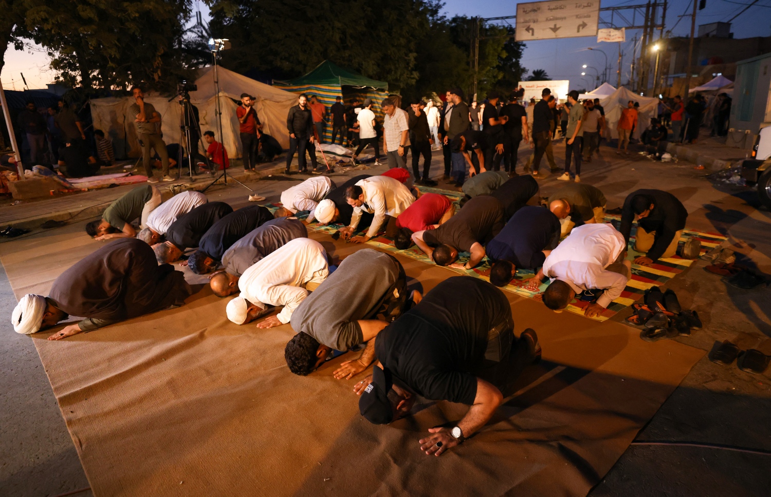 އޮކްޓޫބަރ 20، 2021؛ އިރާގުގައި ބޭއްވި އާންމު އިންތިހާބުގެ ނަތީޖާއާ ދެކޮޅު ހެދުމުގެ ގޮތުން ވެރިރަށް ބަގުދާދުގައި ބޭއްވި މުޒާހަރާގައި ބައިވެރިވި ބަޔަކު އިރު އޮއްސުމުން މަޣުރިބު ނަމާދު ކުރަނީ. --އޭއެފްޕީ