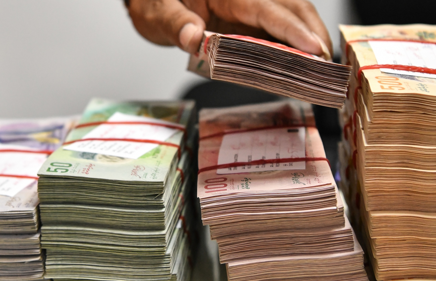 ބޭންކެއްގައި ހުރި ފައިސާތަކެއް ގުނަނީ. ބޭންކްތަކުން ލޯނާއި ކްރެޑިޓް ކާޑަށް ދޫކުރި ފައިސާގެ އަދަދު ވަނީ އެއް އަހަރުން އަނެއް އަހަރަށް އިތުރުވަމުން -- ފޮޓޯ: ނިޝާން އަލީ / މިހާރު