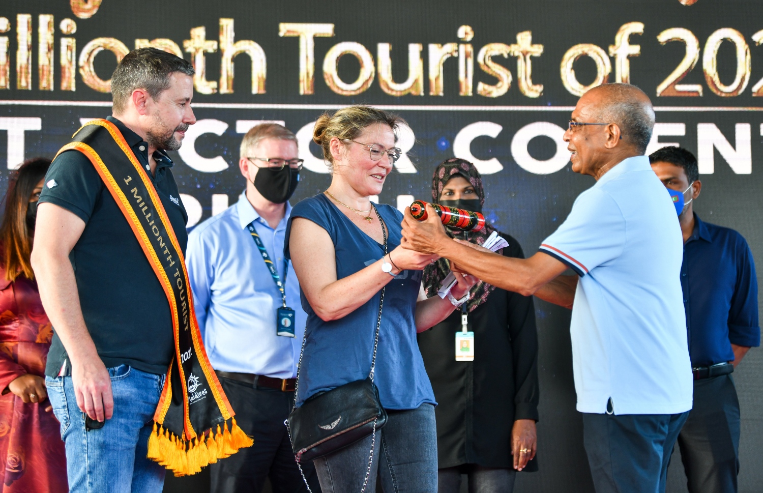 ވެލާނާ އެއާޕޯޓް: އޮކްޓޫބަރު 29، 2021- މި އަހަރު ރާއްޖެ އައި އެއް މިލިއަން ވަނަ ޓޫރިސްޓް ފްރާންސްގެ ވިންސެންޓް ވިކްޓާ ކޮރެން ޕިޓާއޫ އާއި އޭނާގެ އަންހެނުންނަށް މަޓީގެ ފަރާތުން ހަދިޔާއެއް ދެނީ.--- ފޮޓޯ: ފަޔާޒު މޫސާ / މިހާރު