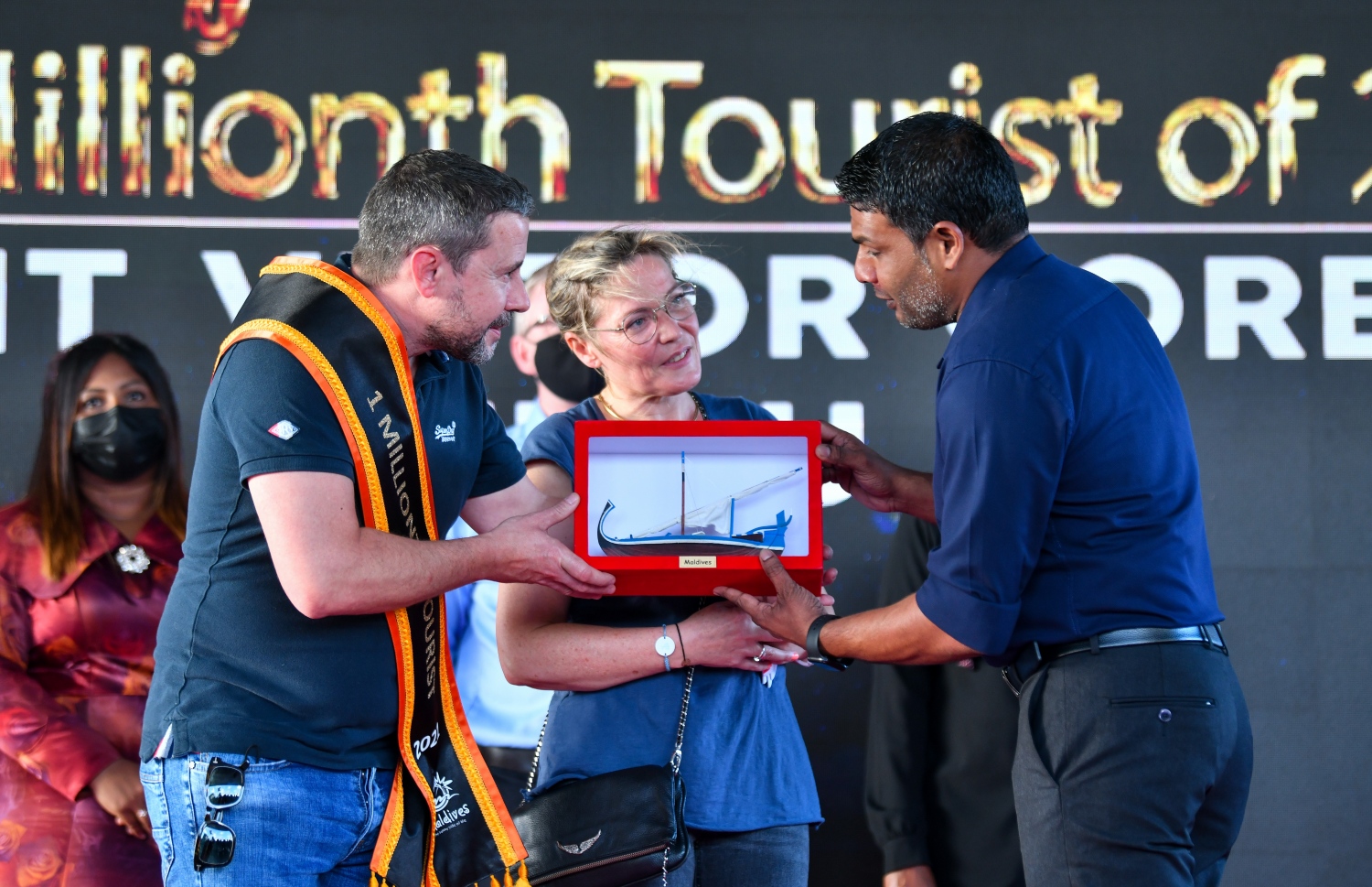 ވެލާނާ އެއާޕޯޓް: އޮކްޓޫބަރު 29، 2021- މި އަހަރު ރާއްޖެ އައި އެއް މިލިއަން ވަނަ ޓޫރިސްޓް ފްރާންސްގެ ވިންސެންޓް ވިކްޓާ ކޮރެން ޕިޓާއޫ އާއި އޭނާގެ އަންހެނުންނަށް އެމްއެމްޕީއާރުސީގެ ފަރާތުން ހަދިޔާއެއް ދެނީ.--- ފޮޓޯ: ފަޔާޒު މޫސާ / މިހާރު