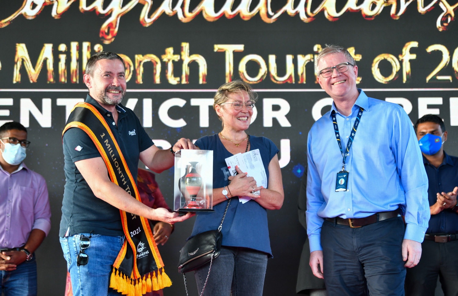 ވެލާނާ އެއާޕޯޓް: އޮކްޓޫބަރު 29، 2021- މި އަހަރު ރާއްޖެ އައި އެއް މިލިއަން ވަނަ ޓޫރިސްޓް ފްރާންސްގެ ވިންސެންޓް ވިކްޓާ ކޮރެން ޕިޓާއޫ އާއި އޭނާގެ އަންހެނުންނަށް އެމްއޭސީއެލް ދިން ހަދިޔާއެއް ދައްކައިލަނީ.--- ފޮޓޯ: ފަޔާޒު މޫސާ / މިހާރު