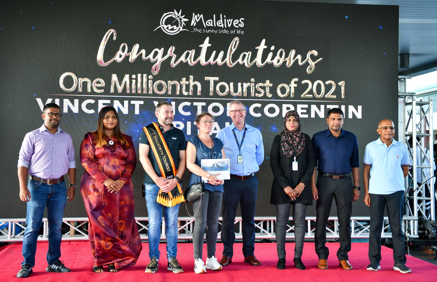 ވެލާނާ އެއާޕޯޓް: އޮކްޓޫބަރު 29، 2021- މި އަހަރު ރާއްޖެ އައި އެއް މިލިއަން ވަނަ ޓޫރިސްޓަކަށް ހޮވި ފްރާންސްގެ ވިންސެންޓް ވިކްޓާ ކޮރެން ޕިޓާއޫ އާއި އޭނާގެ އަންހެނުން، ޓޫރިޒަމް މިނިސްޓްރީ އާއި އެމްއެމްޕީއާރުސީ އާއި އިމިގްރޭޝަނާއި އެމްއޭސީއެލް އަދި މަޓީގެ އިސް ބޭފުޅުންނާ އެކު ފޮޓޯއަކަށް ހުއްޓިގެން-- ފޮޓޯ: ފަޔާޒު މޫސާ / މިހާރު