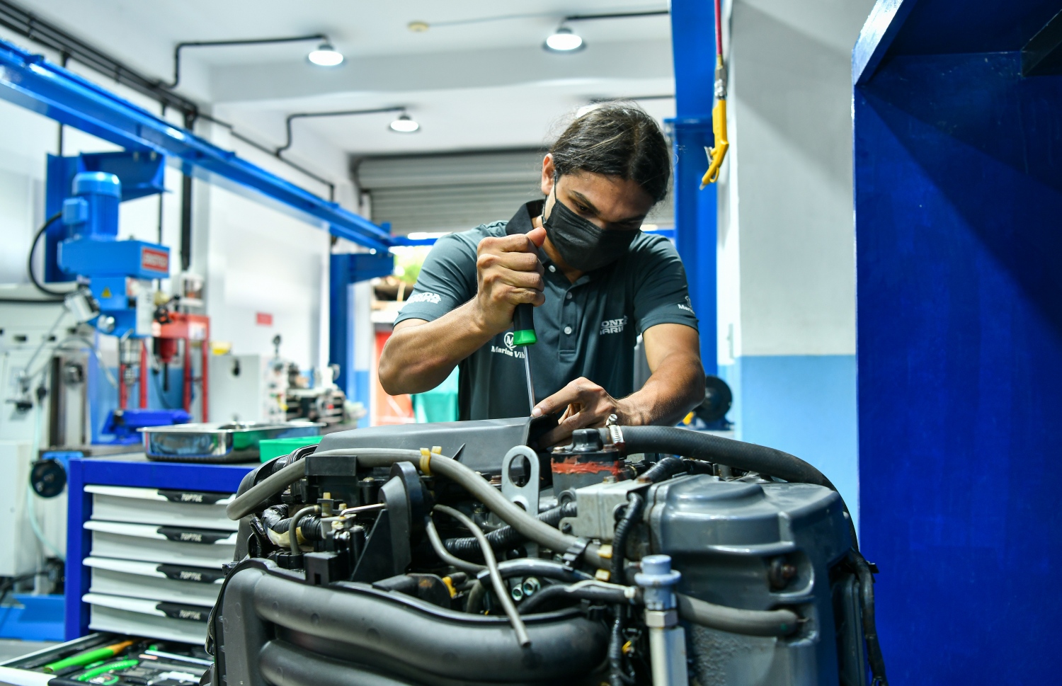 ހޮންޑާ ސާވިސް ސެންޓަރުގެ މުވައްޒަފަކު ހޮންޑާ އިންޖީނެއް މަރާމާތު ކުރަނީ: އެ ސެންޓަރުގެ ހުރިހާ މުވައްޒަފުންނަކީ ވެސް ހޮންޑާ އައުޓްބޯޑު އިންޖީނު ހެދުމުގެ ތަމްރީން ލިބިފައި ތިބި މުވައްޒަފުން-- ފޮޓޯ: ފަޔާޒު މޫސާ/މިހާރު