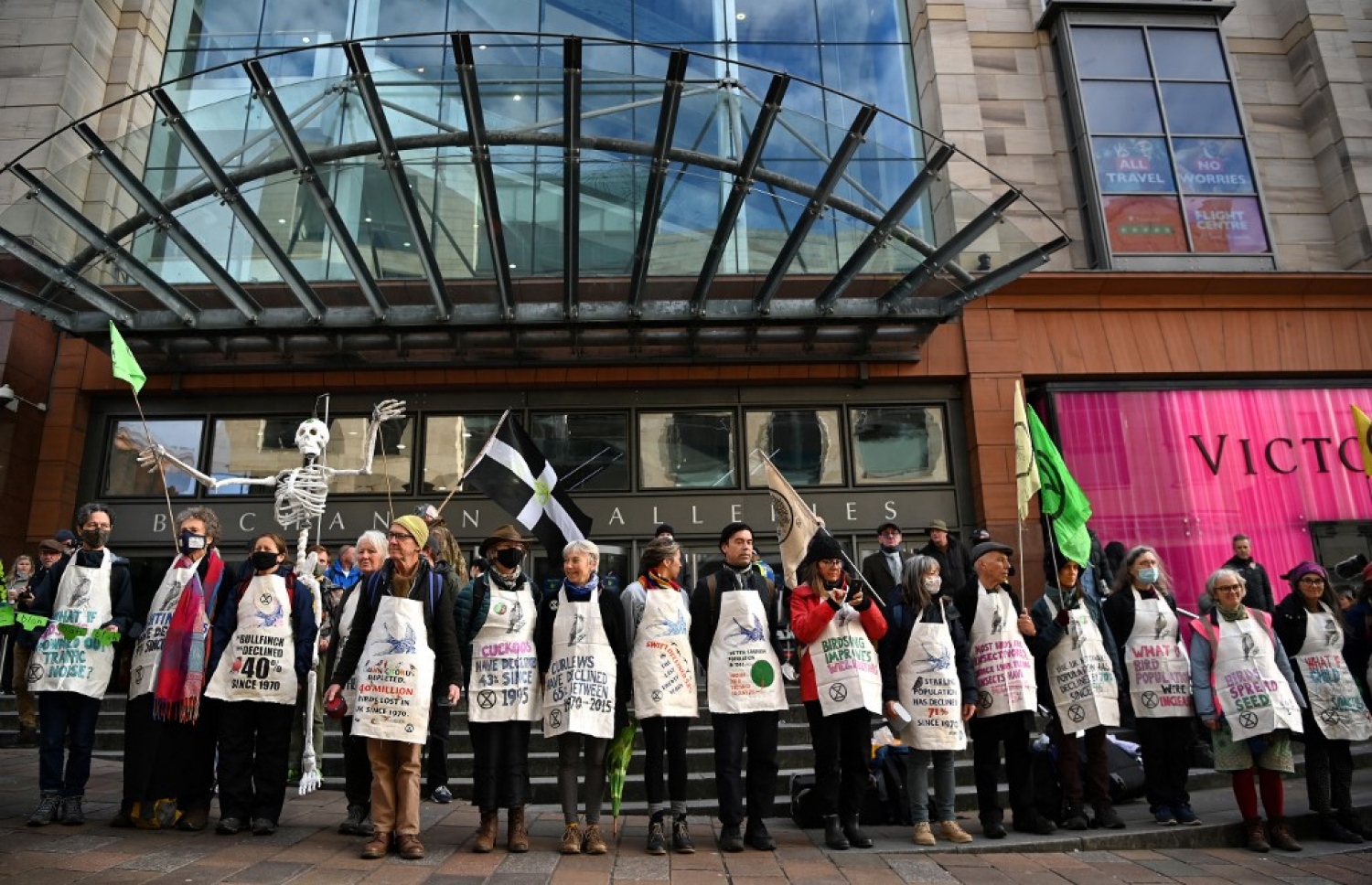 އިނގިރޭސި ވިލާތުގެ ގްލެސްގޯގައި މިހާރު ކުރިއަށް ދާ ތިމާވެށީގެ މަހާސިންތާގެ ބައްދަލުވުމެއް ހިނގަމުން ދިޔަ އިމާރާތެއްގެ ބޭރުގައި، ތިމާވެށީގެ ހިމާޔަތުގައި މަސައްކަތް ކުރާ ޖަމިއްޔާއެއްގެ ބަޔަކު މުޒާހަރާ ކުރަނީ. --އޭއެފްޕީ