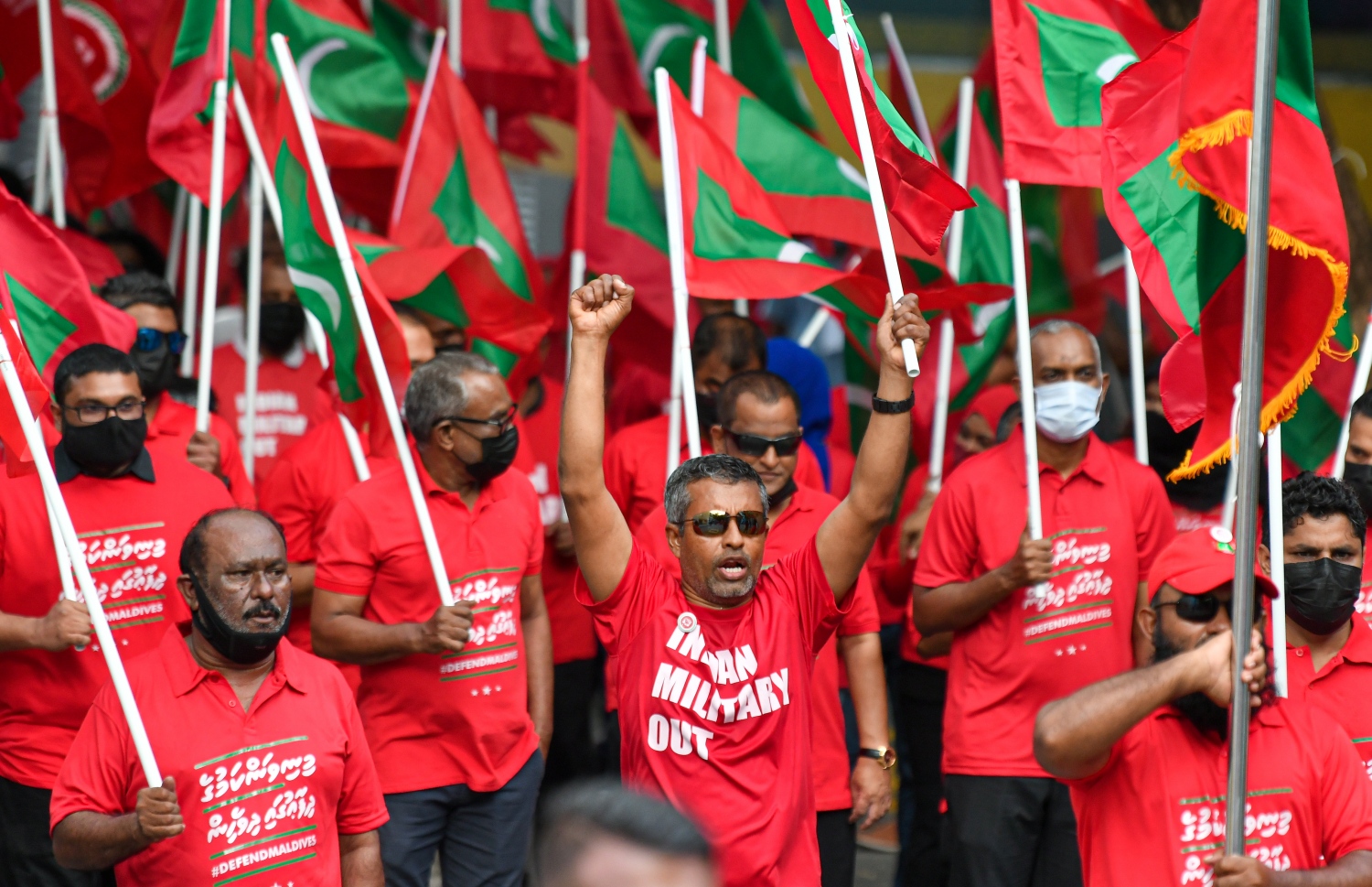 މާލެ- ނޮވެމްބަރު 12، 2021: "މިނިވަންކަމުގެ ދިފާއުގައި" ގެ ނަމުގައި އިދިކޮޅު ކޯލިޝަނުން ބޭއްވި ހިނގާލުމުގެ ބައިވެރިން ރަތްކުލައިގެ ޓީޝާޓު ލައިގެން ގައުމީ ދިދަ ހިފައިގެން ތިބެ، ރާއްޖޭގައި އުޅޭ އިންޑިއާގެ ސިފައިން ފައިބަން ގޮވާލައި އަޑުއުފުލަނީ.---ފޮޓޯ: ފަޔާޒު މޫސާ/ މިހާރު