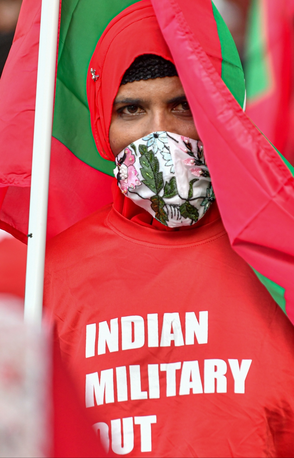 މާލެ- ނޮވެމްބަރު 12، 2021: ރާއްޖޭގައި ތިބޭ އިންޑިއާގެ ސިފައިން ފައިބައިގެން ދިއުމަށް ގޮވާލައި އިދިކޮޅު ކޯލިޝަނުން މިއަދު ހަވީރު ބޭއްވި ހިނގާލުމުގެ ބައިވެރިއަކު ގައުމީ ދިދަ އާއި އެ ހަރަކާތަށް ބޭނުންކުރާ ރަތްކުލައިގެ ޓީޝާޓް ލައިގެން ހުރެ ޝުއޫރު ފާޅުކުރަނީ.---ފޮޓޯ: ފަޔާޒު މޫސާ/ މިހާރު