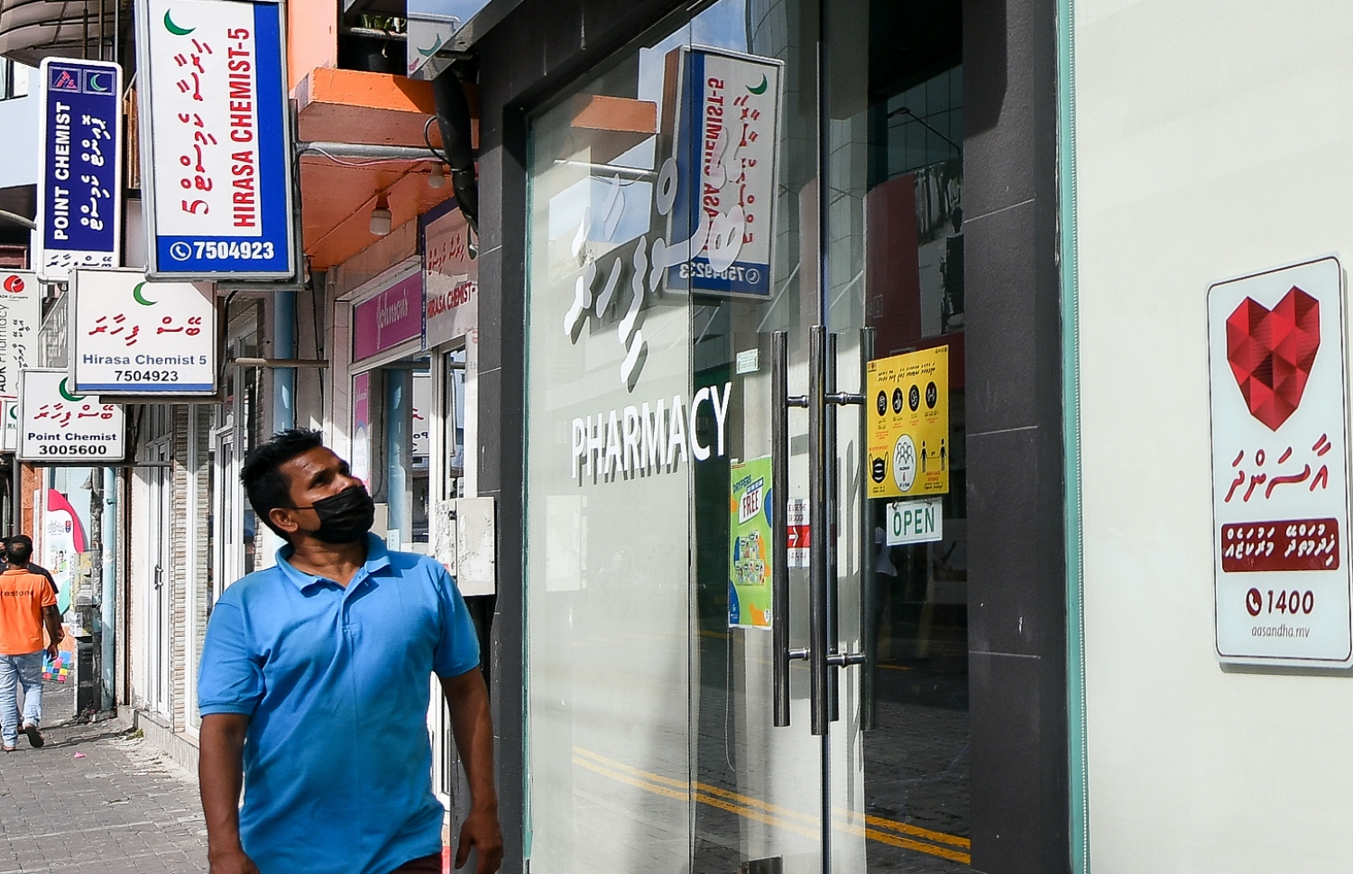 ފާމަސީއެއް ކައިރިން މީހަކު ހިނގާލާފައި ދަނީ.-- ފޮޓޯ: ފަޔާޒު މޫސާ/ މިހާރު