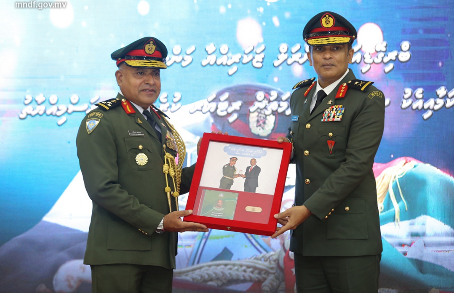 ބްރިގޭޑިއާ ޖެނެރަލް ޒަކަރިއްޔާ މަންސޫރު ޝަރަފުވެރިކަމާ އެކު ރިޓަޔާކުރެއްވުމުން ޗީފް އޮފް ޑިފެންސް ފޯް މޭޖާ ޖެނެރލް އަބްދުﷲ ޝަމާލް އޭނާއަށް ފޮޓޯ ލޯގަނޑެއް ދެއްވަނީ. ފޮޓޯ: އެމްއެންޑީއެފް