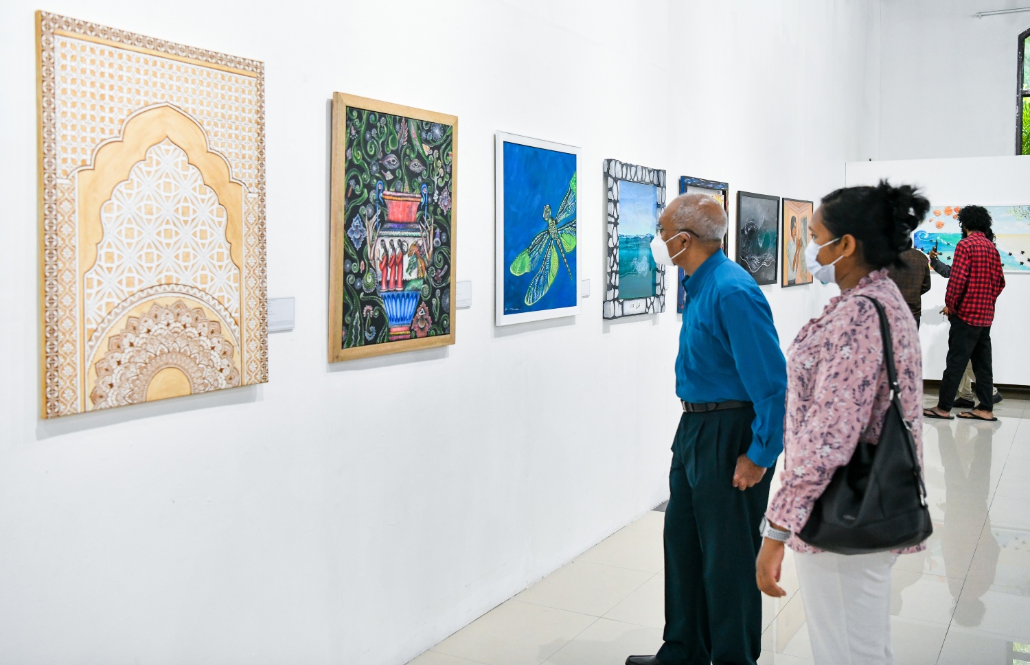 ޑިސެމްބަރު 10، 2021: އަންވެއިލިން ވިޝަންސް އާޓް އެގްޒިބިޝަންގެ ދިވެހިން ކުރެހުންތެރިންގެ ކުރެހުންތައް ބަޔަކު ބަލާލަނީ.-- ފޮޓޯ- ނިޝާން އަލީ / މިހާރު