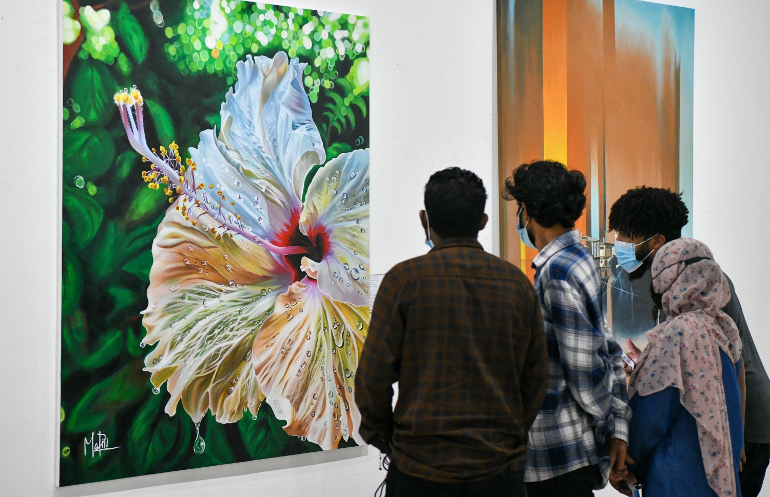 ޑިސެމްބަރު 10، 2021: އަންވެއިލިން ވިޝަންސް އާޓް އެގްޒިބިޝަންގެ ދިވެހިން ކުރެހުންތެރިންގެ ކުރެހުންތައް ބަޔަކު ބަލާލަނީ.-- ފޮޓޯ- ނިޝާން އަލީ / މިހާރު