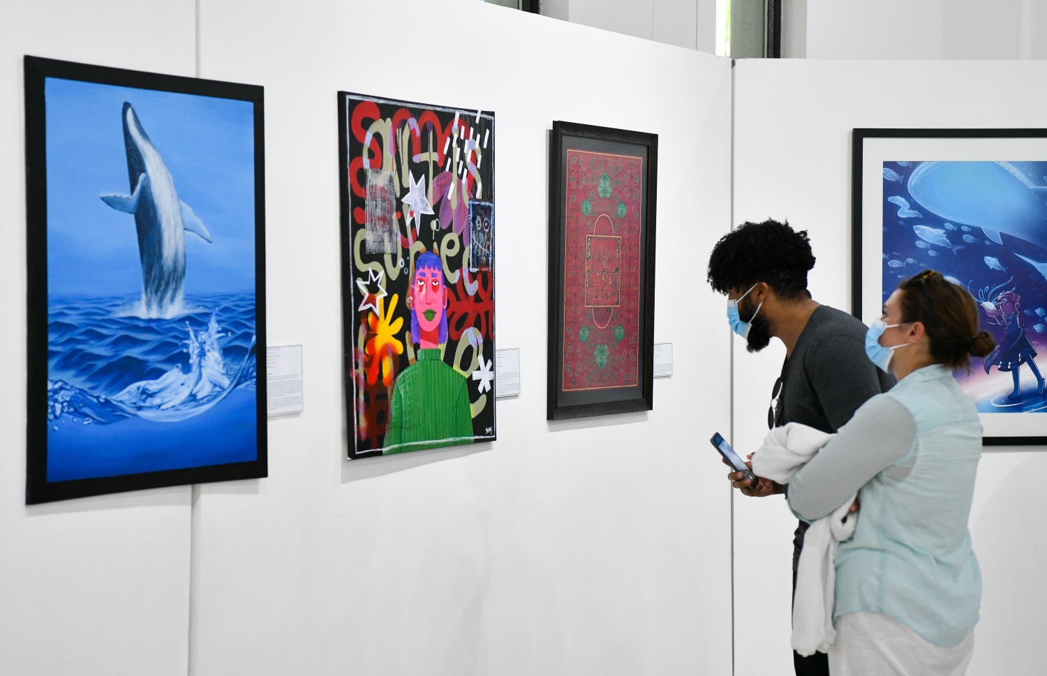 ޑިސެމްބަރު 10، 2021: އަންވެއިލިން ވިޝަންސް އާޓް އެގްޒިބިޝަންގެ ދިވެހިން ކުރެހުންތެރިންގެ ކުރެހުންތައް ބަޔަކު ބަލާލަނީ.--- ފޮޓޯ- ނިޝާން އަލީ / މިހާރު