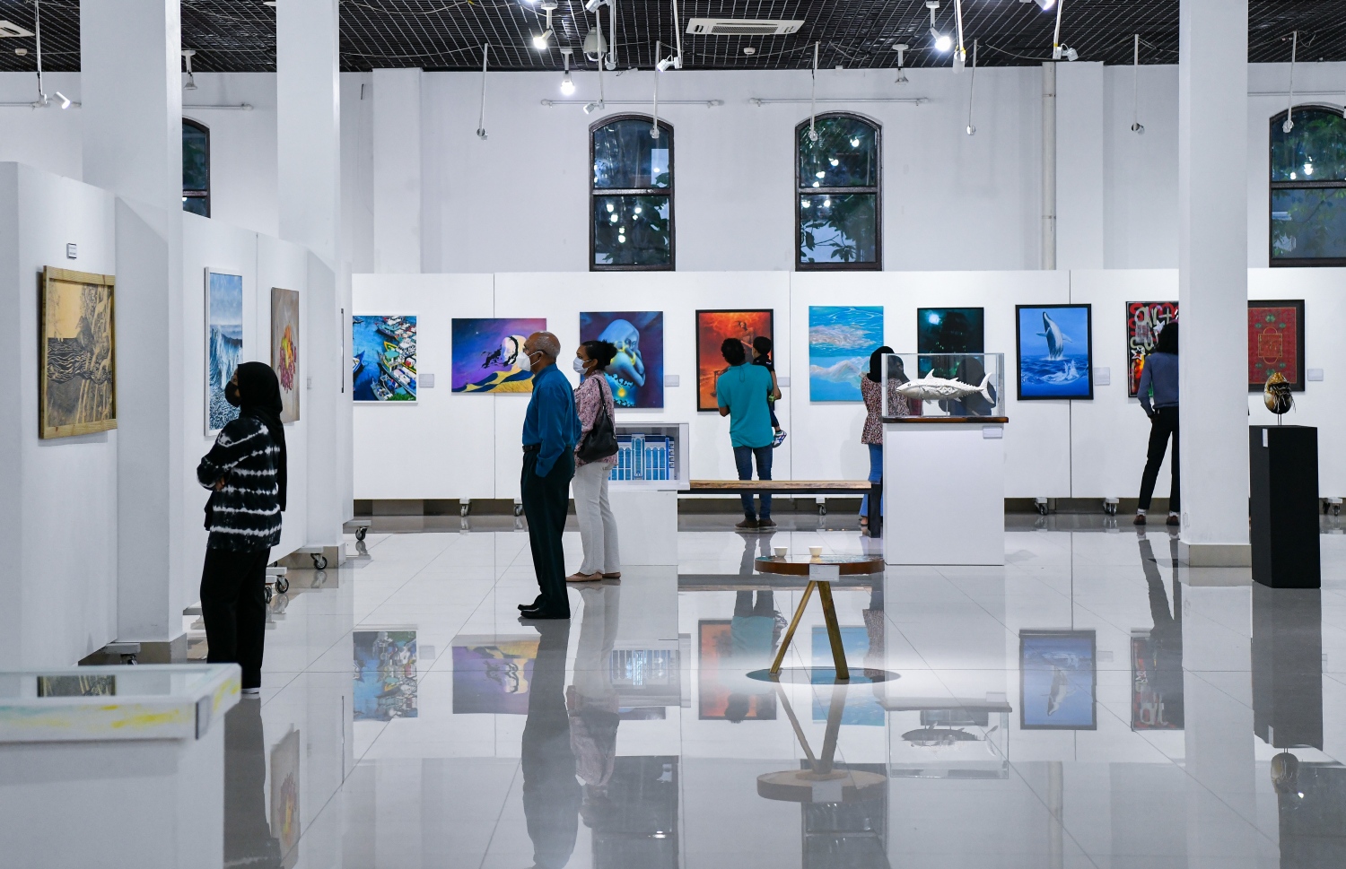 ޑިސެމްބަރު 10، 2021: އަންވެއިލިން ވިޝަންސް އާޓް އެގްޒިބިޝަންގެ ދިވެހިން ކުރެހުންތެރިންގެ ކުރެހުންތައް ބަޔަކު ބަލާލަނީ.-- ފޮޓޯ- ނިޝާން އަލީ / މިހާރު