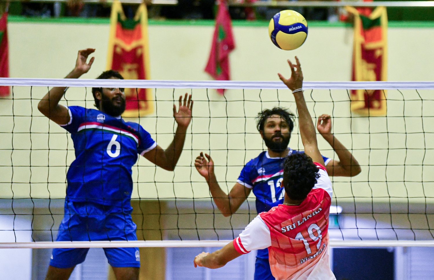 މާލެ- ޑިސެމްބަރު 12، 2021: ގައުމީ ވޮލީ ޓީމު ސްރީލަންކާއާ ދެކޮޅަށް ކުޅުނު ބައިނަލްއަގުވާމީ އެކުވެރިކަމުގެ މެޗުގައި ލަންކާ ކުޅުންތެރިއެއް ރާއްޖޭގެ ކޯޓަށް ބޯޅަ ވައްޓާލަން އުޅޭއިރު ރާއްޖޭގެ ކުޅުންތެރިން ސަމާލުވެގެން. -- ފޮޓޯ: ފަޔާޒު މޫސާ / މިހާރު