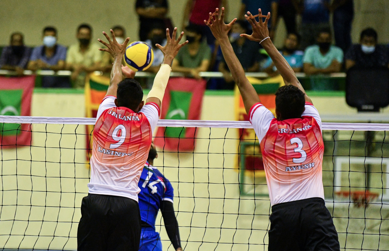 މާލެ- ޑިސެމްބަރު 12، 2021: ގައުމީ ވޮލީ ޓީމު ސްރީލަންކާއާ ދެކޮޅަށް ކުޅުނު ބައިނަލްއަގުވާމީ އެކުވެރިކަމުގެ މެޗުގައި ރާއްޖޭގެ ކުޅުންތެރިއެއްގެ ޝޮޓެއް ލަންކާ ކުޅުންތެރިން ދިފާއު ކުރަނީ. -- ފޮޓޯ: ފަޔާޒު މޫސާ / މިހާރު