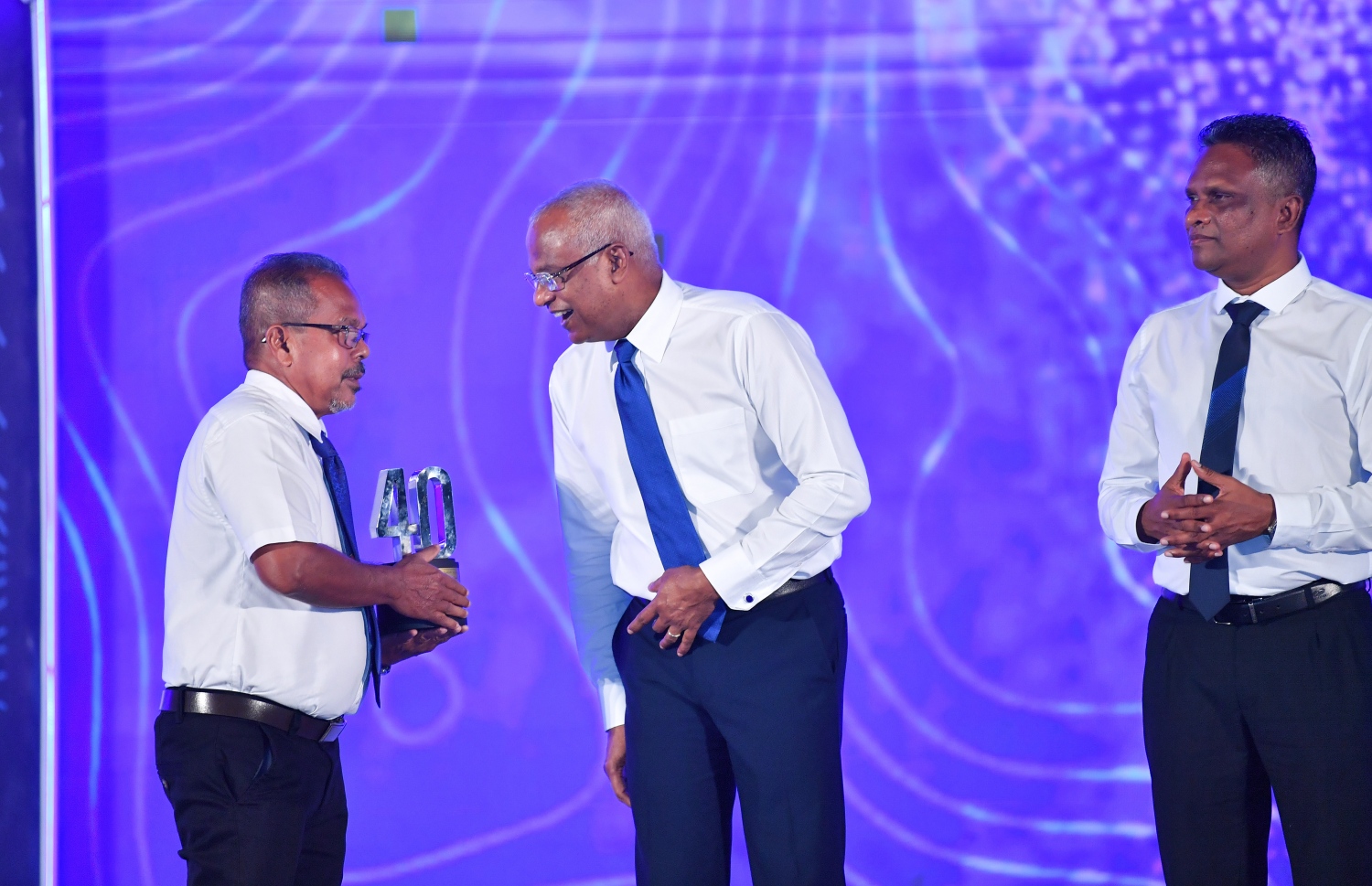 މާލެ: ޑިސެމްބަރު 19، 2021: އެމްޓީސީސީގެ 41 ވަނަ އަހަރީ ދުވަސް ފާހަގަކުރަން ބޭއްވި ޖަލްސާގައި އެ ކުންފުންޏަށް ގިނަ ދުވަހު ހިދުމަތް ކޮށްދިން މުވައްޒަފަކަށް ރައީސް އިބްރާހިމް މުހައްމަދު ސޯލިހު ހަނދާނީ ފިލައެއް ދެއްވުމަށްފަހު އޭނާ އަށް މަރުހަބާ ކިޔުއްވަނީ.-- ފޮޓޯ: ރައީސް އޮފީސް