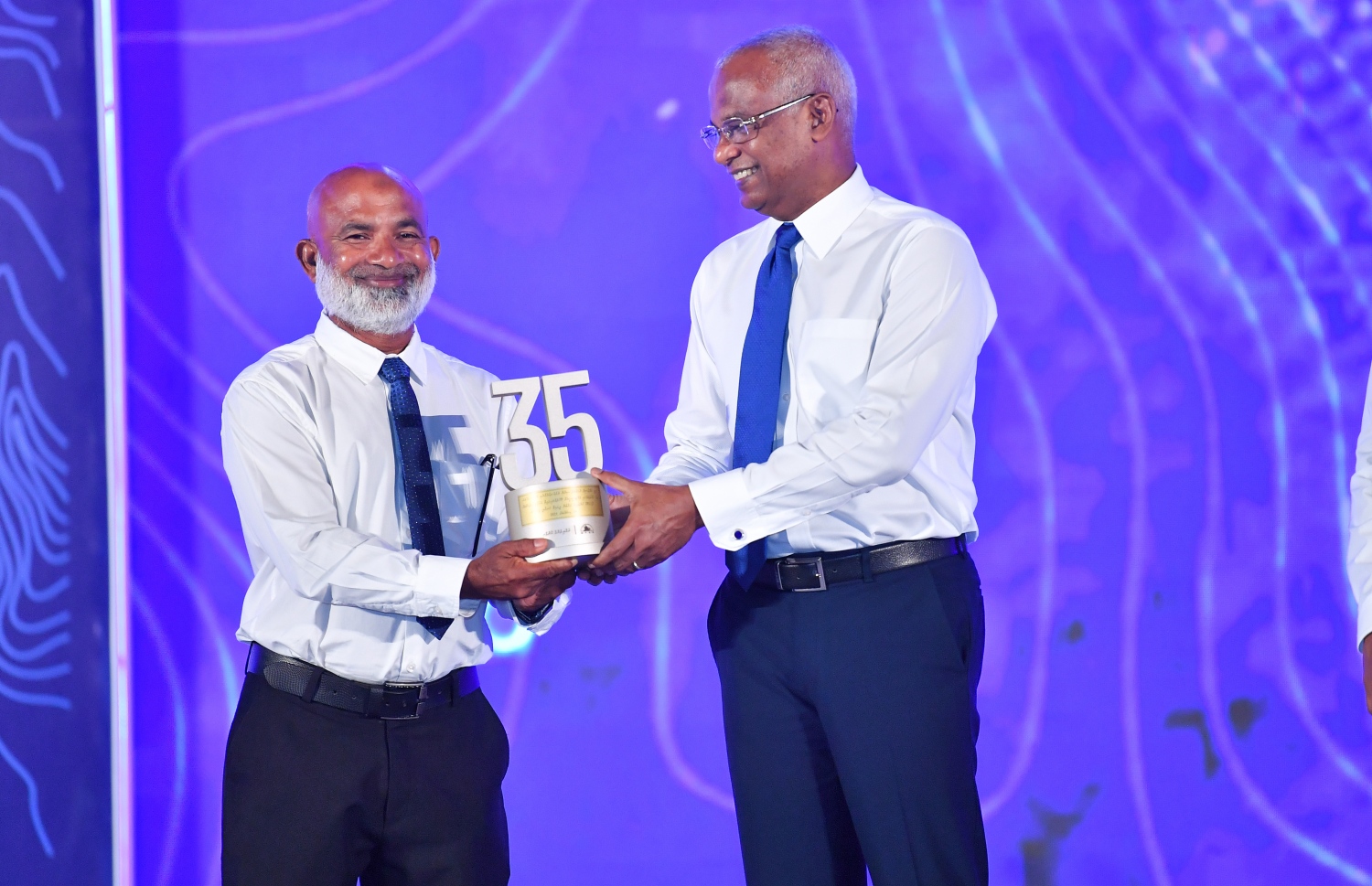 މާލެ: ޑިސެމްބަރު 19، 2021: އެމްޓީސީސީގެ 41 ވަނަ އަހަރީ ދުވަސް ފާހަގަކުރަން ބޭއްވި ޖަލްސާގައި އެ ކުންފުންޏަށް ގިނަ ދުވަހު ހިދުމަތް ކޮށްދިން މުވައްޒަފަކަށް ރައީސް އިބްރާހިމް މުހައްމަދު ސޯލިހު ހަނދާނީ ފިލައެއް ދެއްވަނީ.-- ފޮޓޯ: ރައީސް އޮފީސް