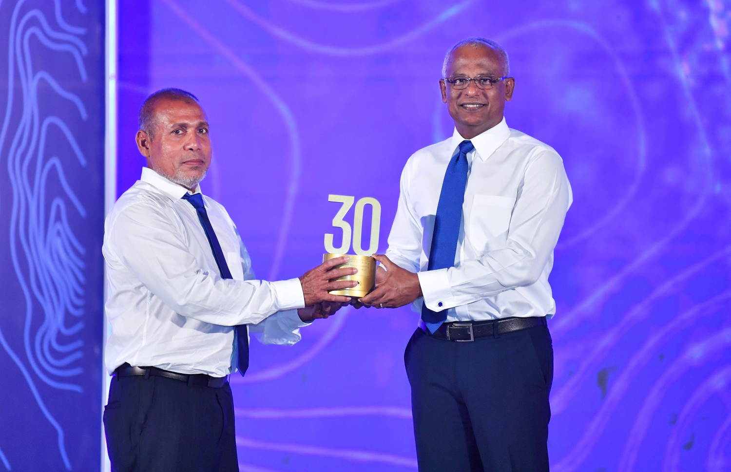 މާލެ: ޑިސެމްބަރު 19، 2021: އެމްޓީސީސީގެ 41 ވަނަ އަހަރީ ދުވަސް ފާހަގަކުރަން ބޭއްވި ޖަލްސާގައި އެ ކުންފުންޏަށް ގިނަ ދުވަހު ހިދުމަތް ކޮށްދިން މުވައްޒަފަކަށް ރައީސް އިބްރާހިމް މުހައްމަދު ސޯލިހު ހަނދާނީ ފިލައެއް ދެއްވަނީ.-- ފޮޓޯ: ރައީސް އޮފީސް