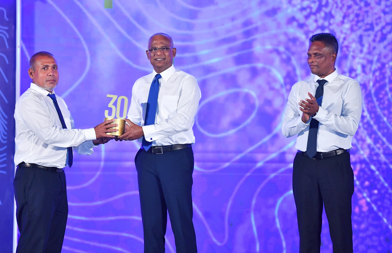 މާލެ: ޑިސެމްބަރު 19، 2021: އެމްޓީސީސީގެ 41 ވަނަ އަހަރީ ދުވަސް ފާހަގަކުރަން ބޭއްވި ޖަލްސާގައި އެ ކުންފުންޏަށް ގިނަ ދުވަހު ހިދުމަތް ކޮށްދިން މުވައްޒަފަކަށް ރައީސް އިބްރާހިމް މުހައްމަދު ސޯލިހު ހަނދާނީ ފިލައެއް ދެއްވަނީ.-- ފޮޓޯ: ރައީސް އޮފީސް