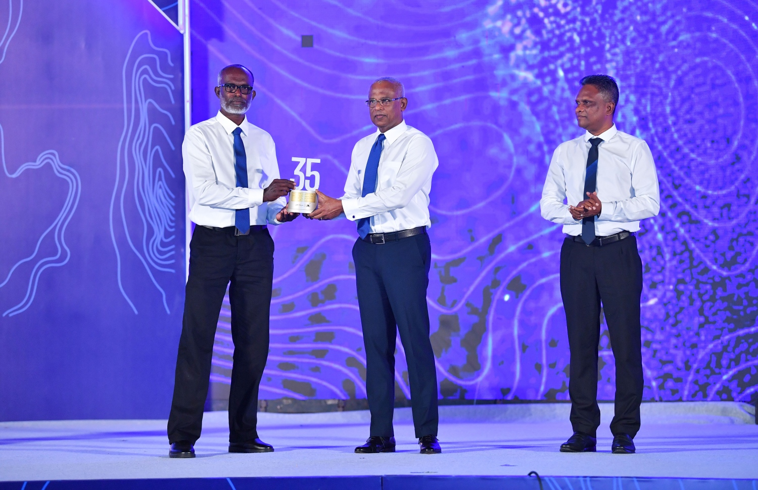 މާލެ: ޑިސެމްބަރު 19، 2021: އެމްޓީސީސީގެ 41 ވަނަ އަހަރީ ދުވަސް ފާހަގަކުރަން ބޭއްވި ޖަލްސާގައި އެ ކުންފުންޏަށް ގިނަ ދުވަހު ހިދުމަތް ކޮށްދިން މުވައްޒަފަކަށް ރައީސް އިބްރާހިމް މުހައްމަދު ސޯލިހު ހަނދާނީ ފިލައެއް ދެއްވަނީ.-- ފޮޓޯ: ރައީސް އޮފީސް